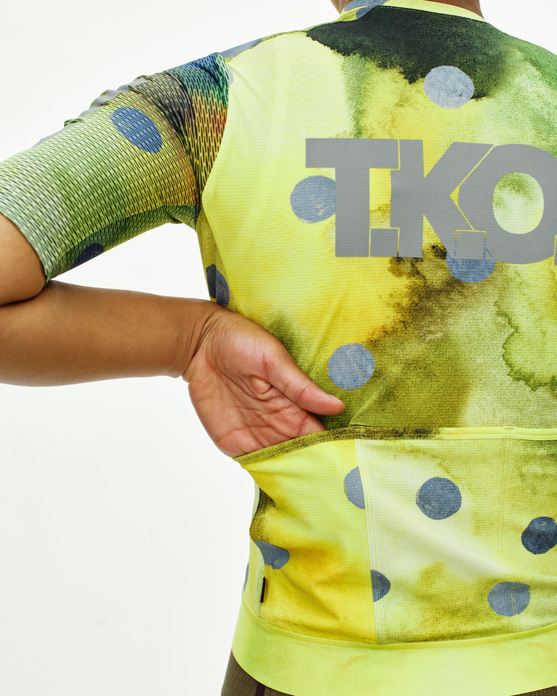 Yellow T.K.O. Essential Light cycling jersey, rear view on model with polka dot print and grey T.K.O. logo