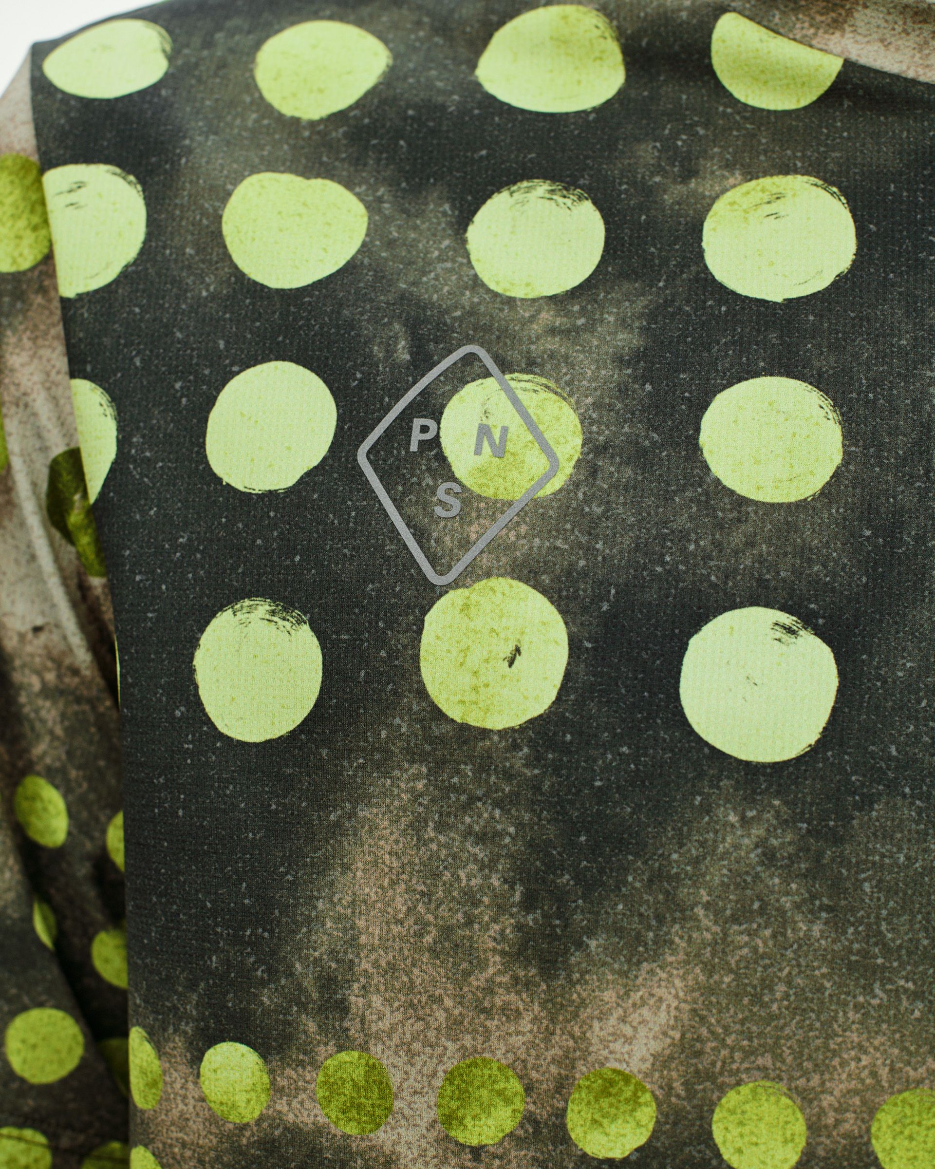 Green T.K.O. Balance t-shirt detail view with lime green polka dot print and diamond logo