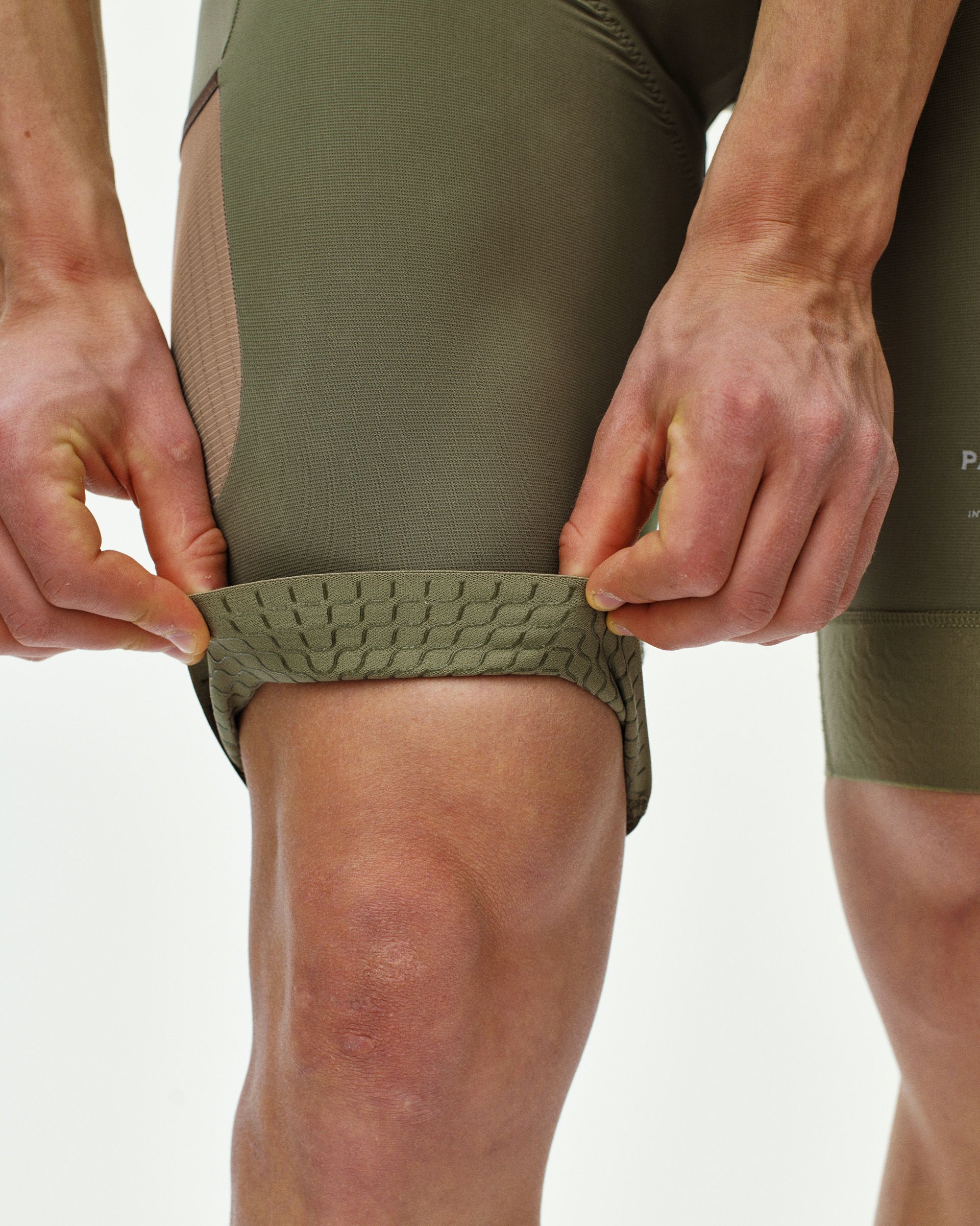 Light Olive Escapism cargo bibs on model showing textured cargo pocket detail