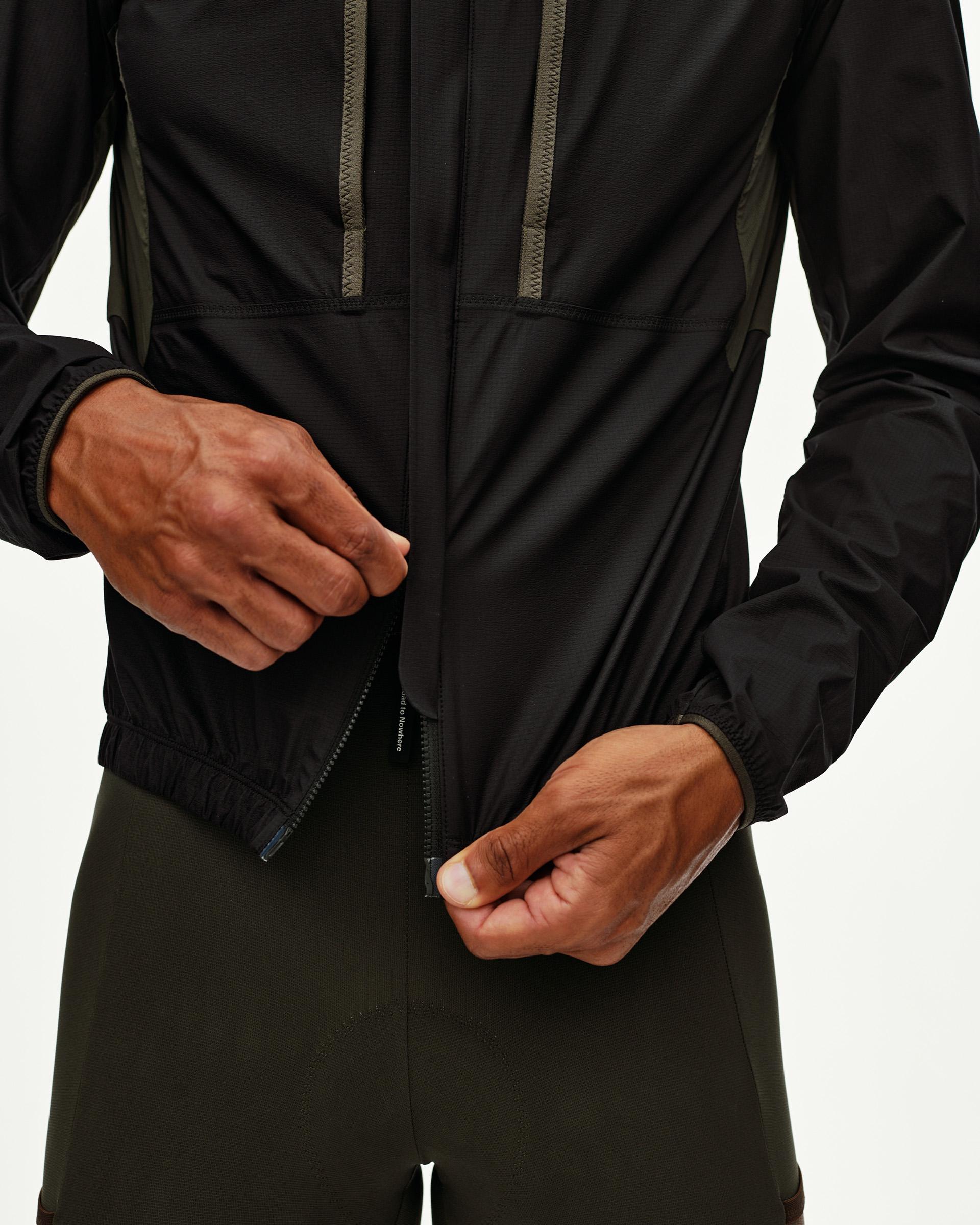 Black Escapism Hooded Lightweight cycling jacket, front detail on model showing zip closure and contrast panel stitching