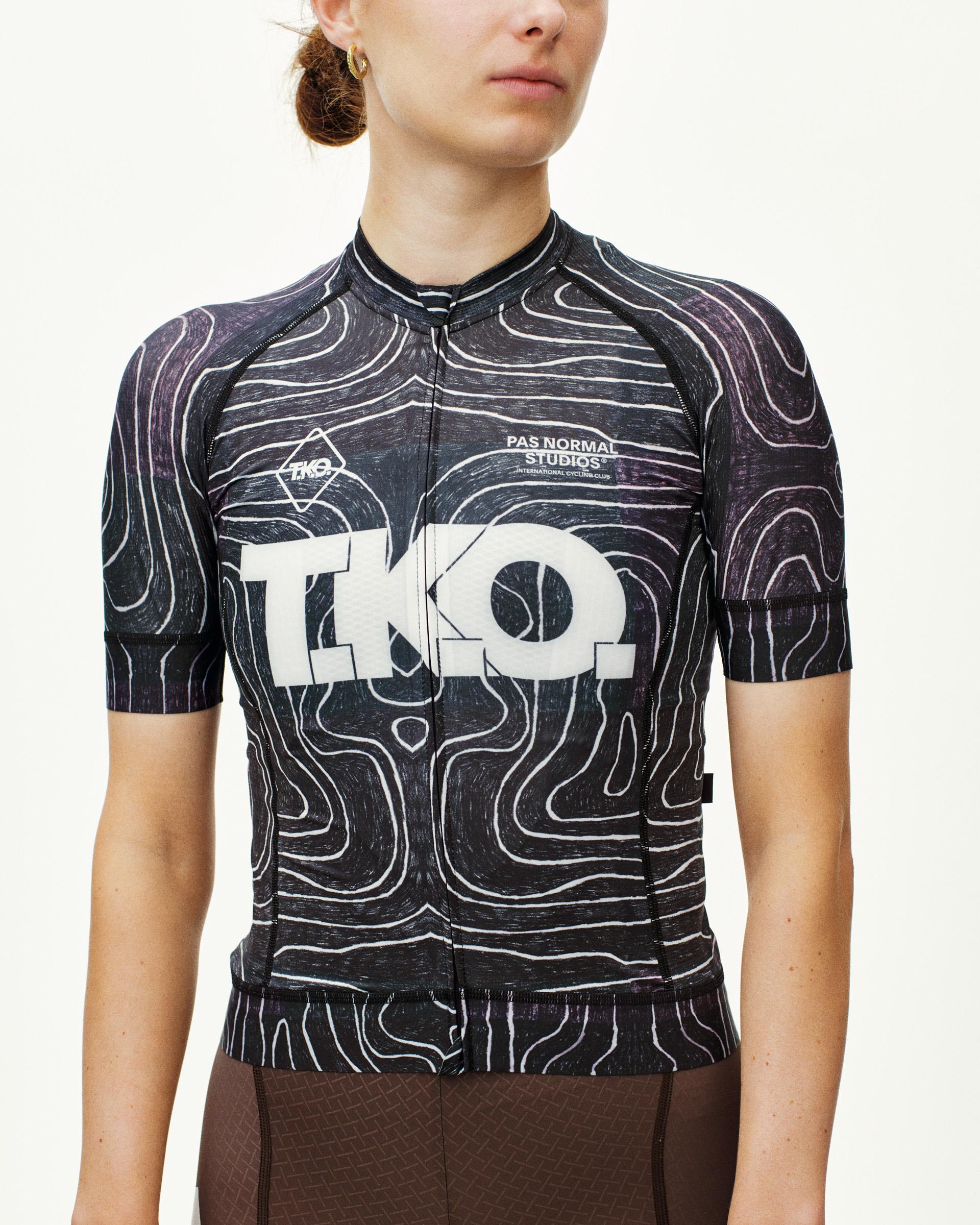 Black T.K.O. Mechanism cycling jersey on model, front view with topographic line print and large chest logo