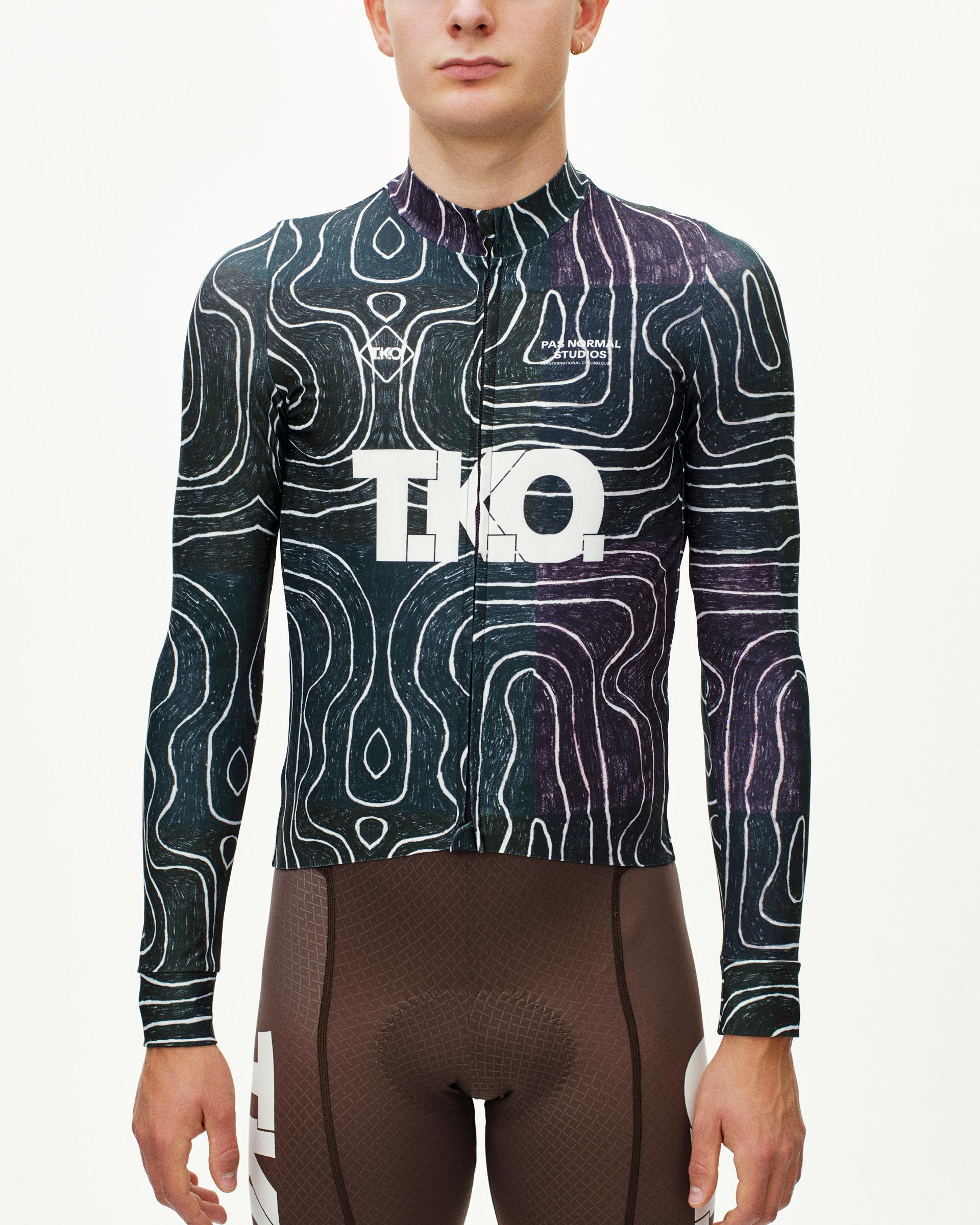 Black Multi T.K.O. Mechanism long sleeve cycling jersey on model, front view with topographic all-over print and white logo