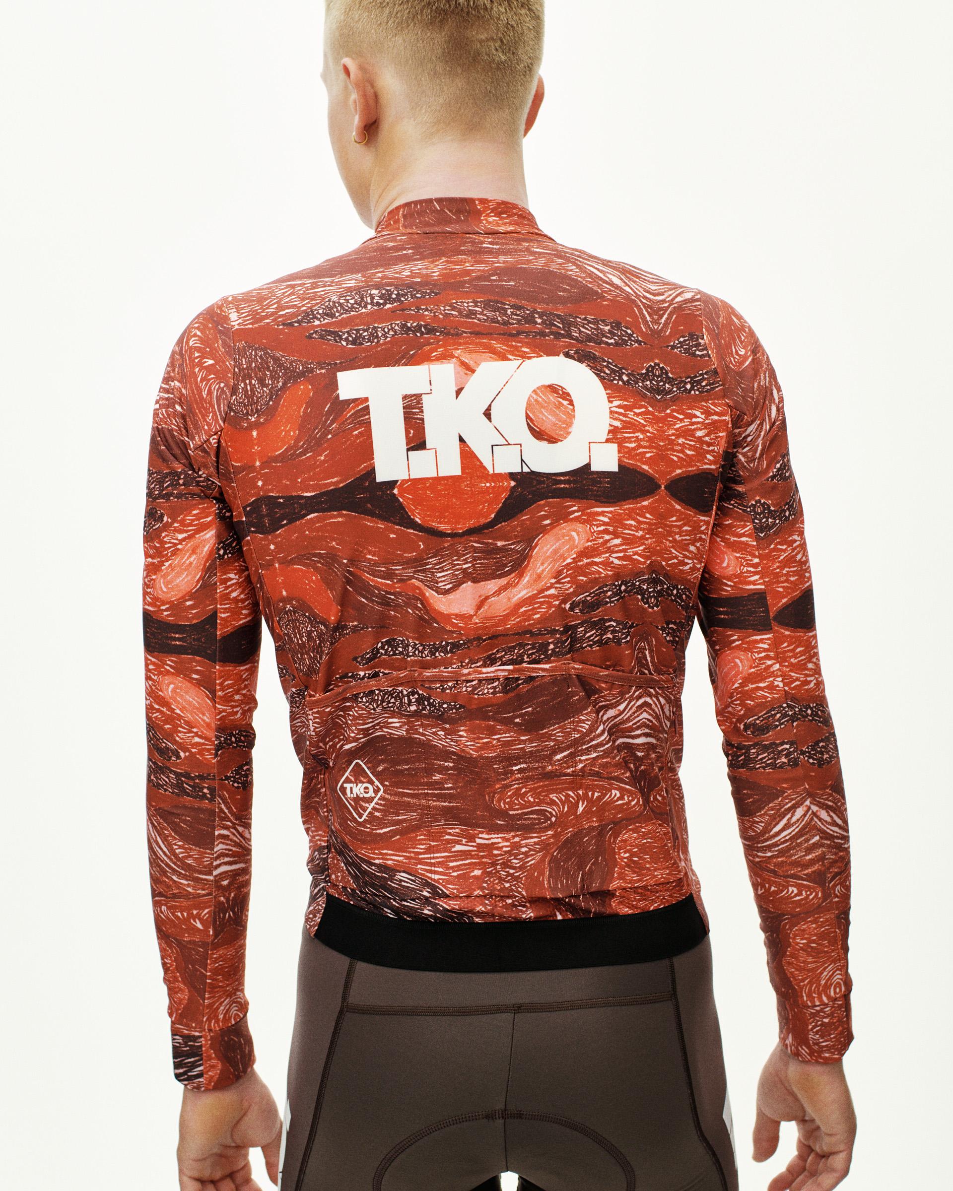 Red T.K.O. Woven long sleeve cycling jersey, rear view on model with white T.K.O. logo and abstract print