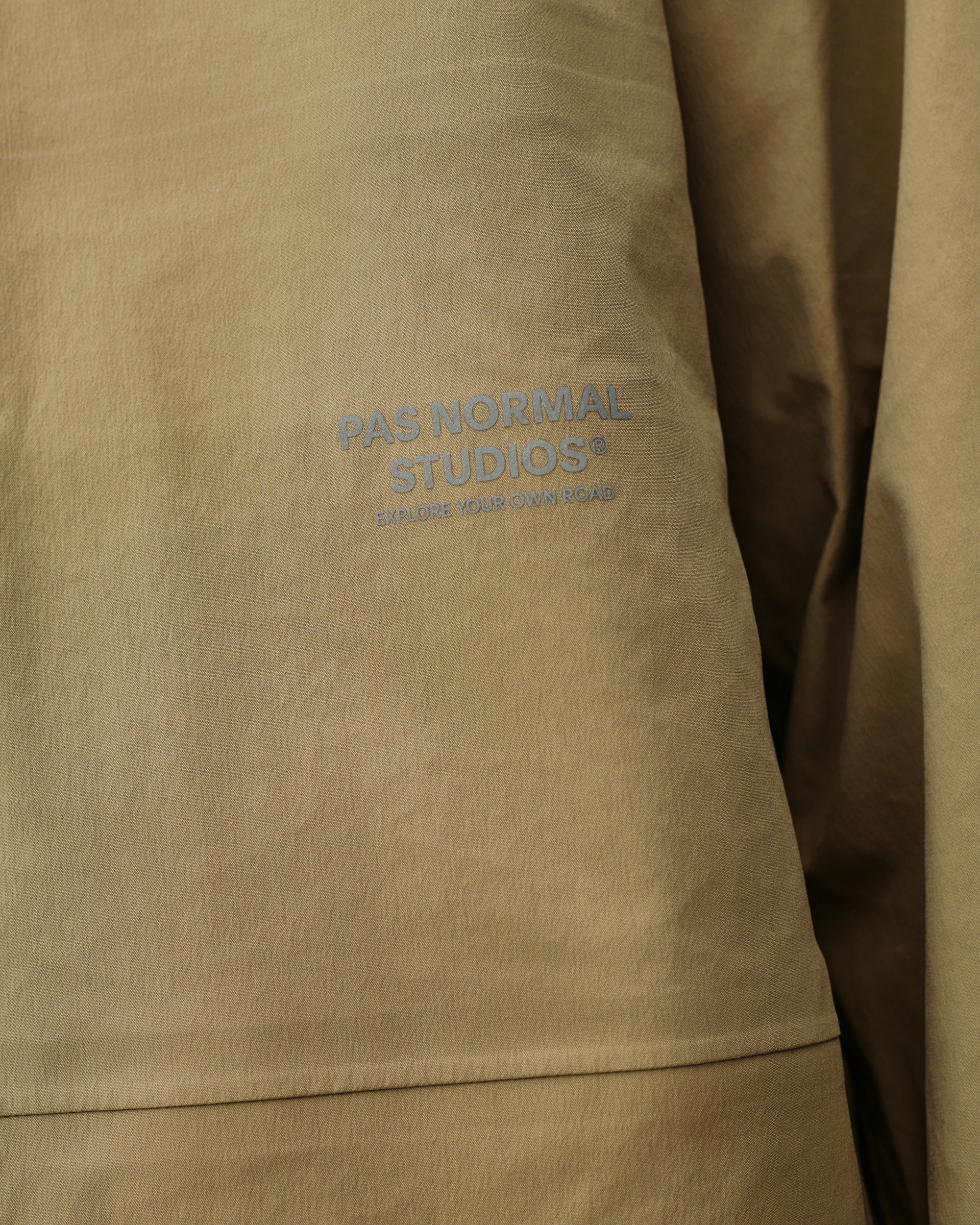 Brown Off-Race 3L Shell jacket, detail view of chest logo print on woven shell fabric
