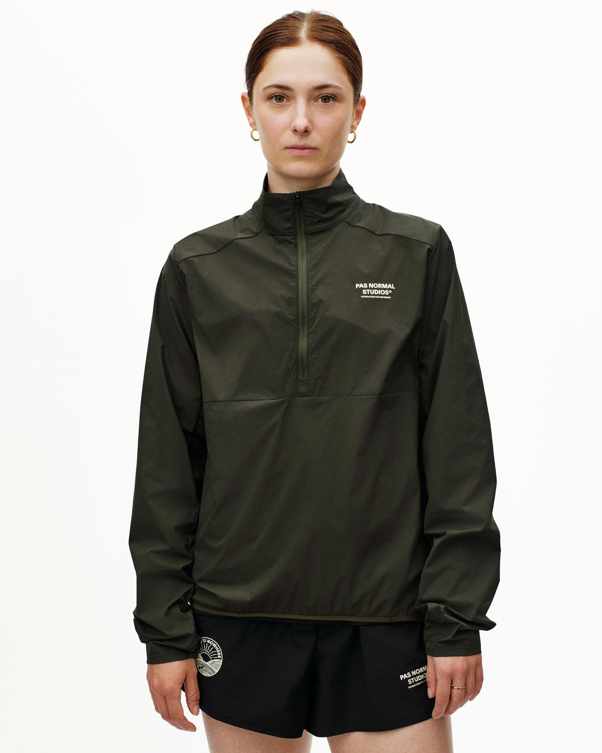 Dark Olive Balance Half Zip jacket on model with white chest logo