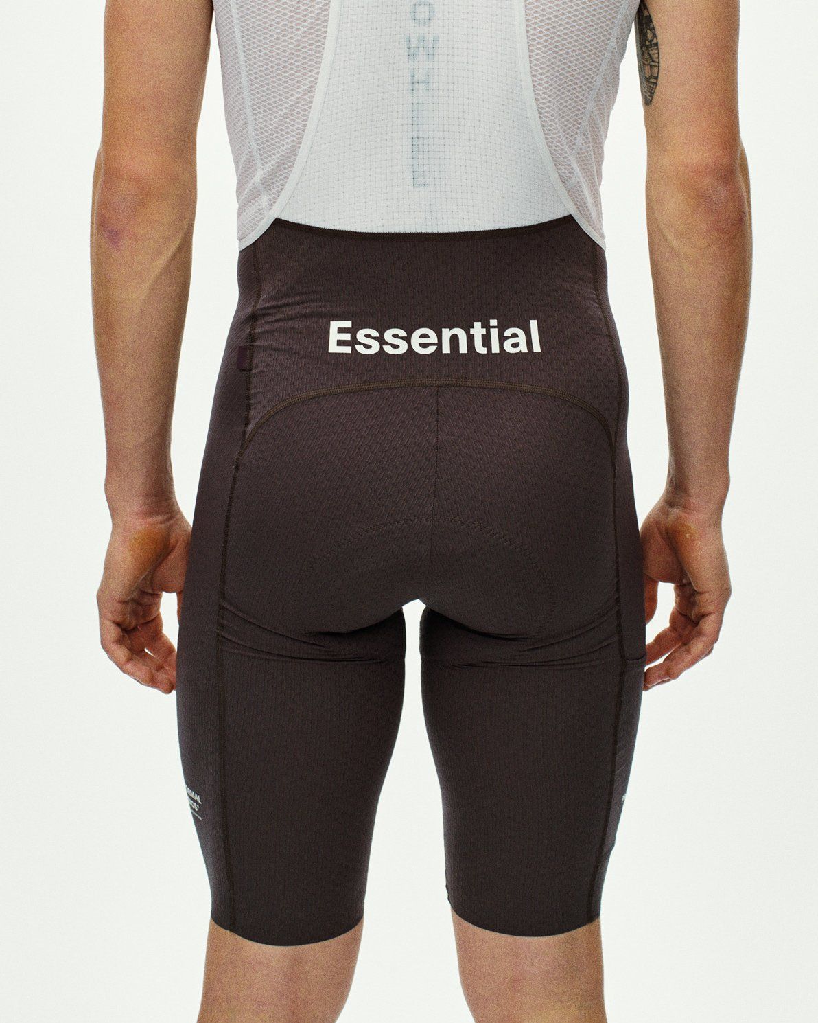 Dark Purple Essential Light Cargo cycling bibs on model, rear view with white Essential waistband print