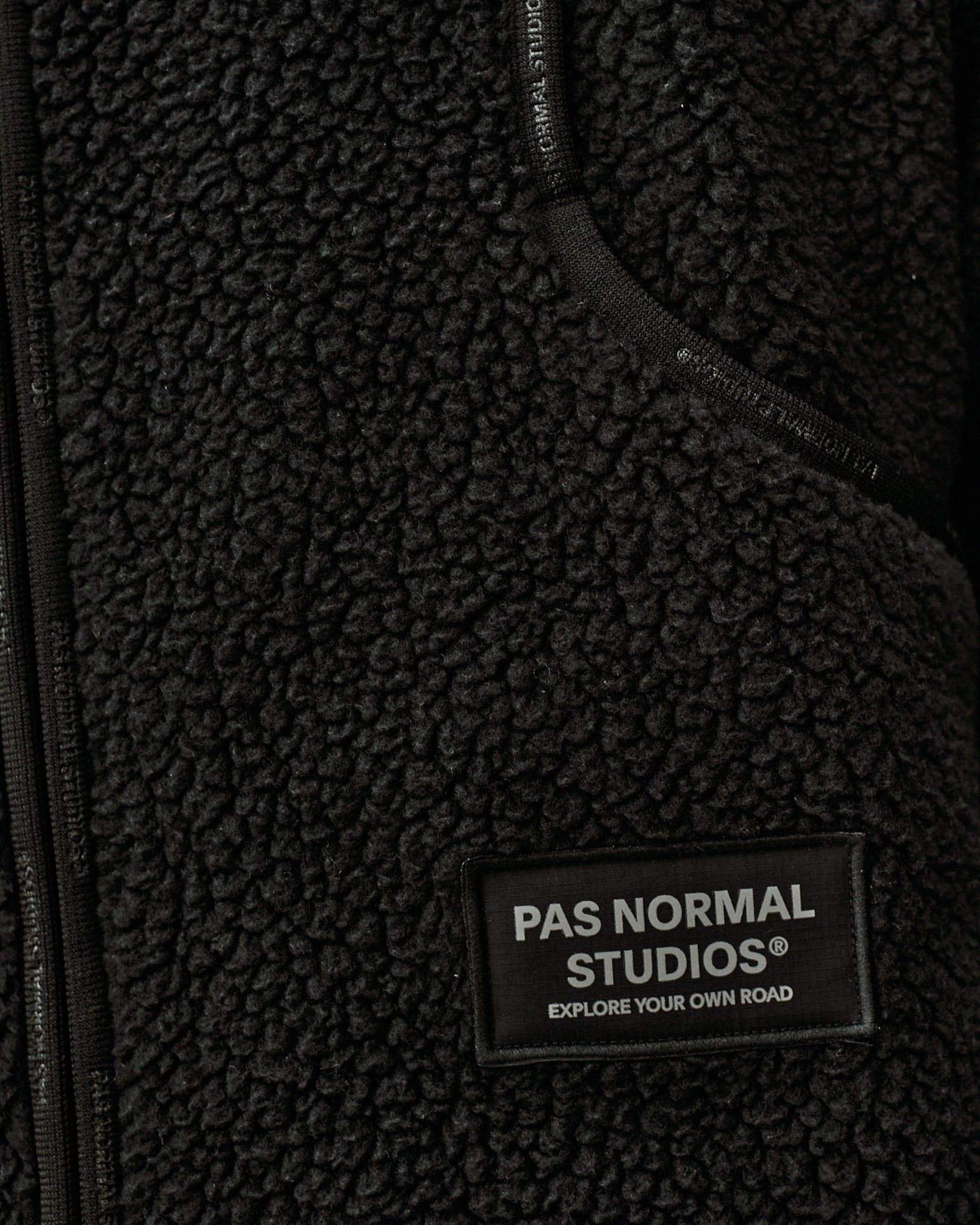Dark Grey Off-Race Pile Fleece vest, detail view showing chest zip pocket and brand patch