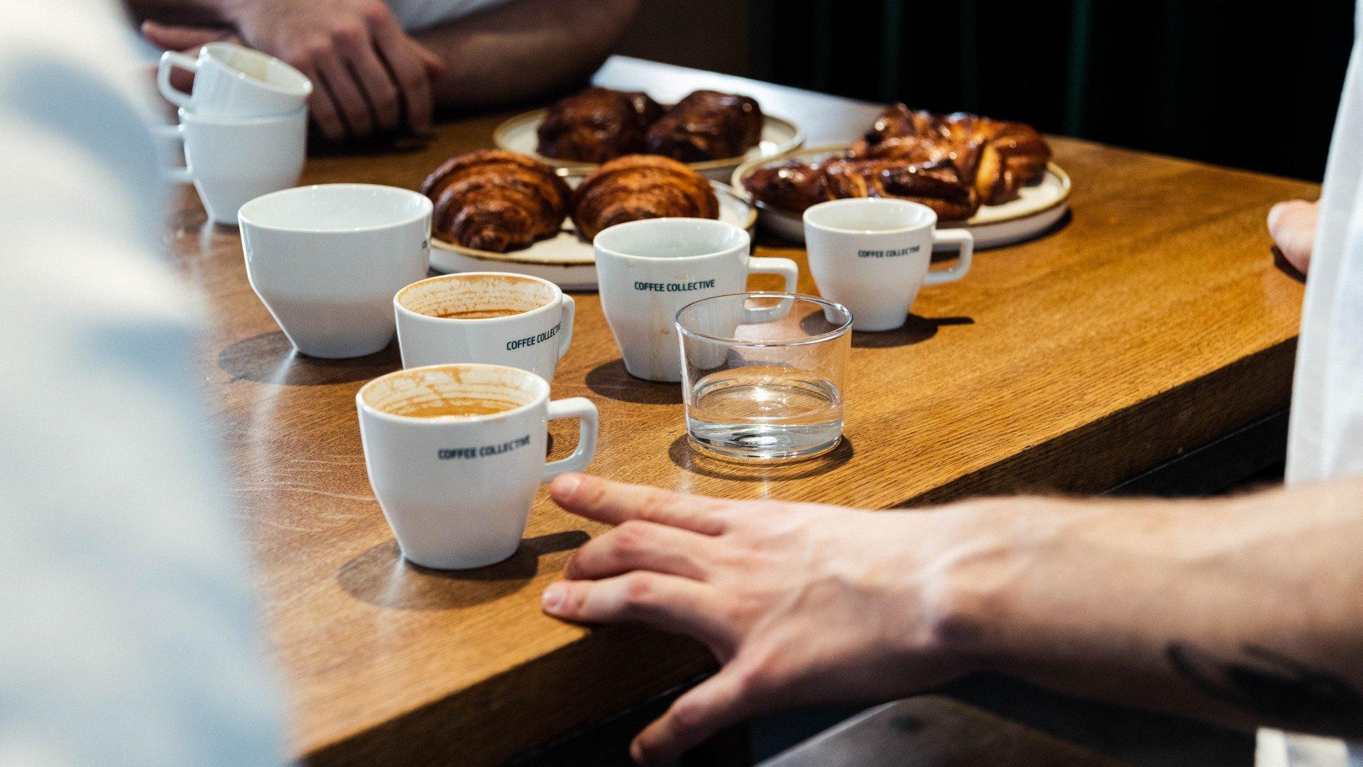 Coffee cups and pastries on wooden table during cafe meeting