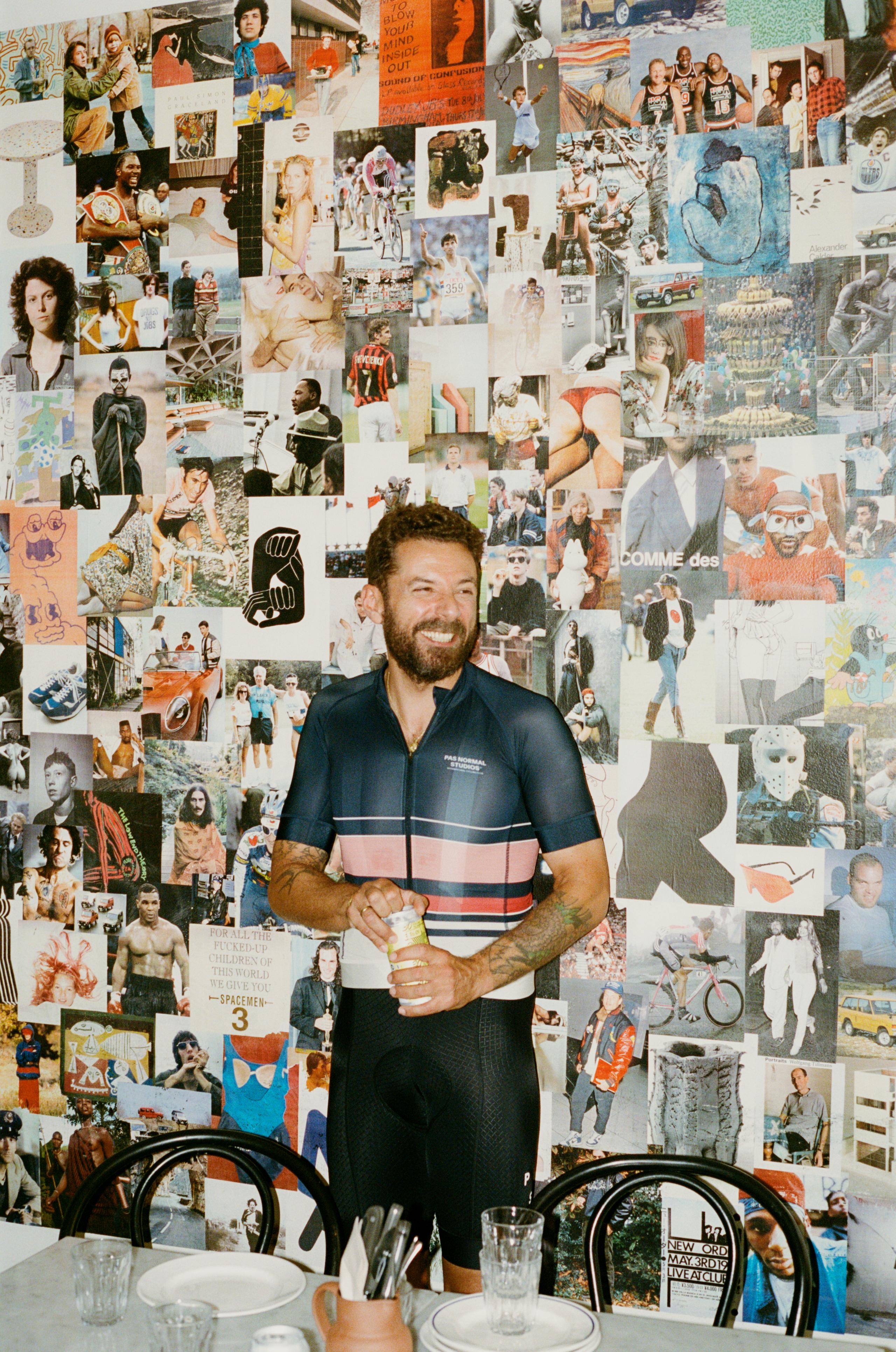 Model wearing dark blue striped cycling jersey with pink accents against mood board wall