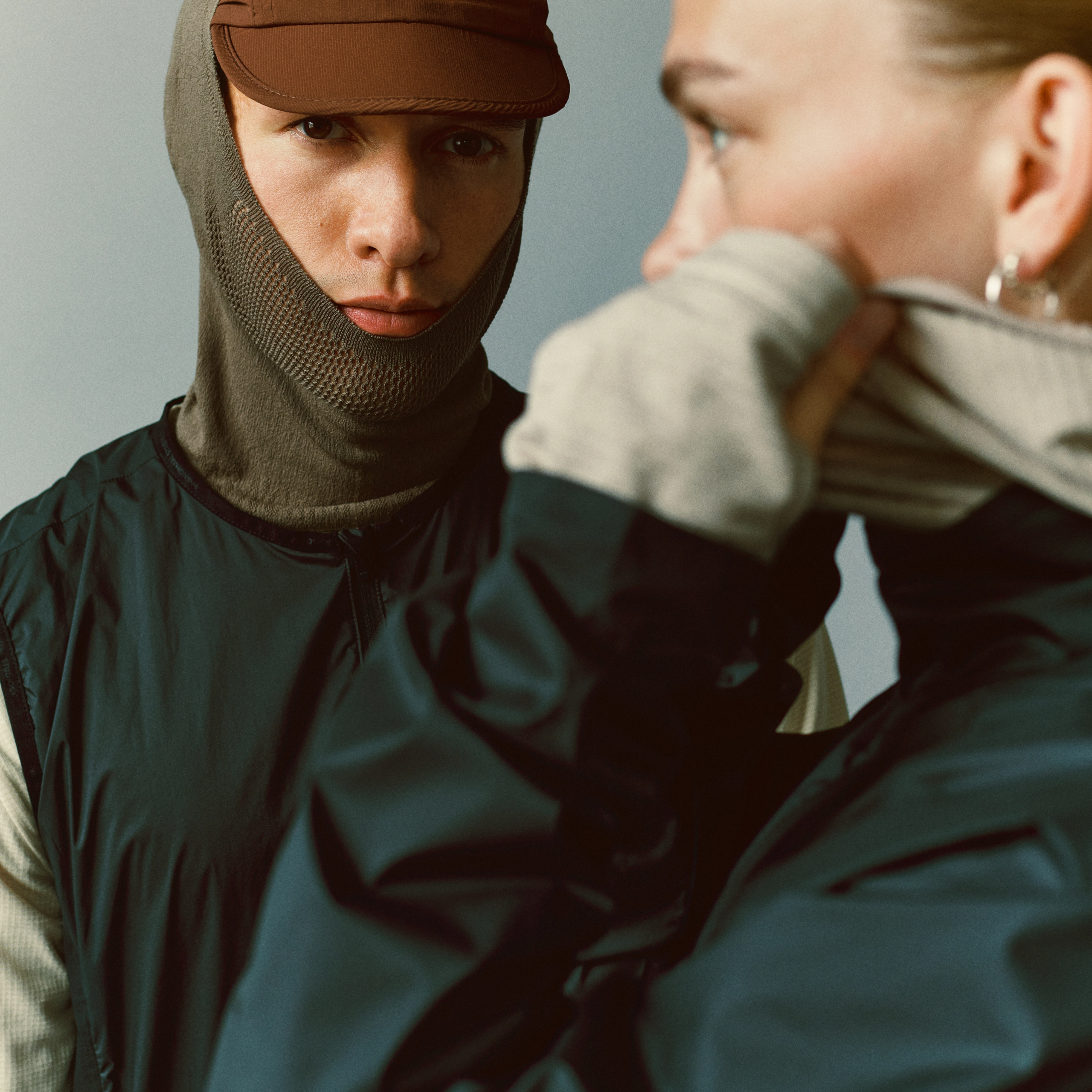 Dark teal Balance cycling windproof vest on model, front view worn over base layer with balaclava