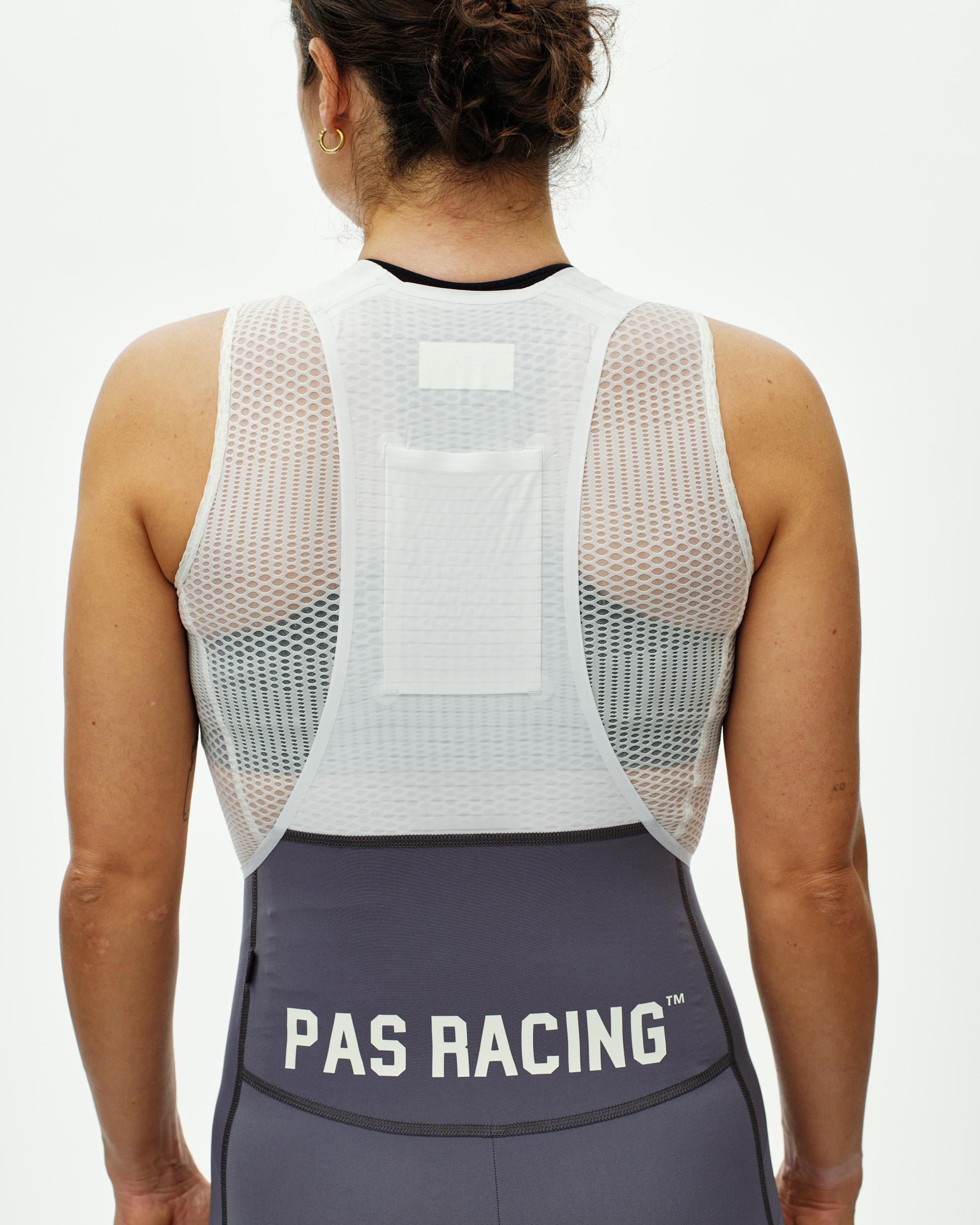 Grey Mechanism Pro Women's cycling bibs, rear view on model with PAS Racing logo waistband