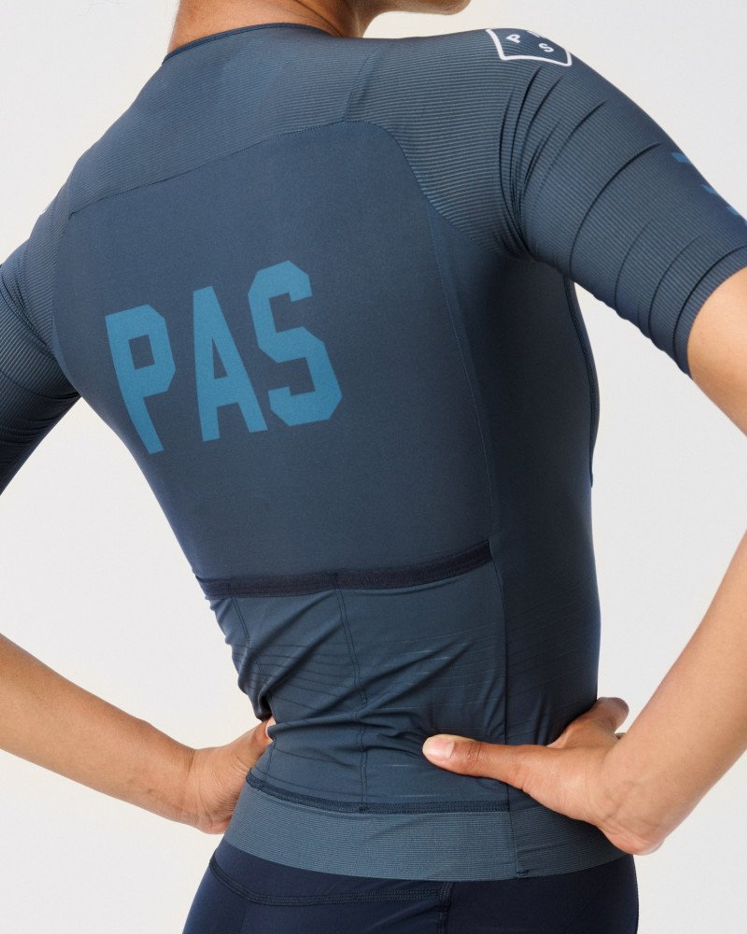 Navy PAS cycling jersey on model, rear view with blue chest print
