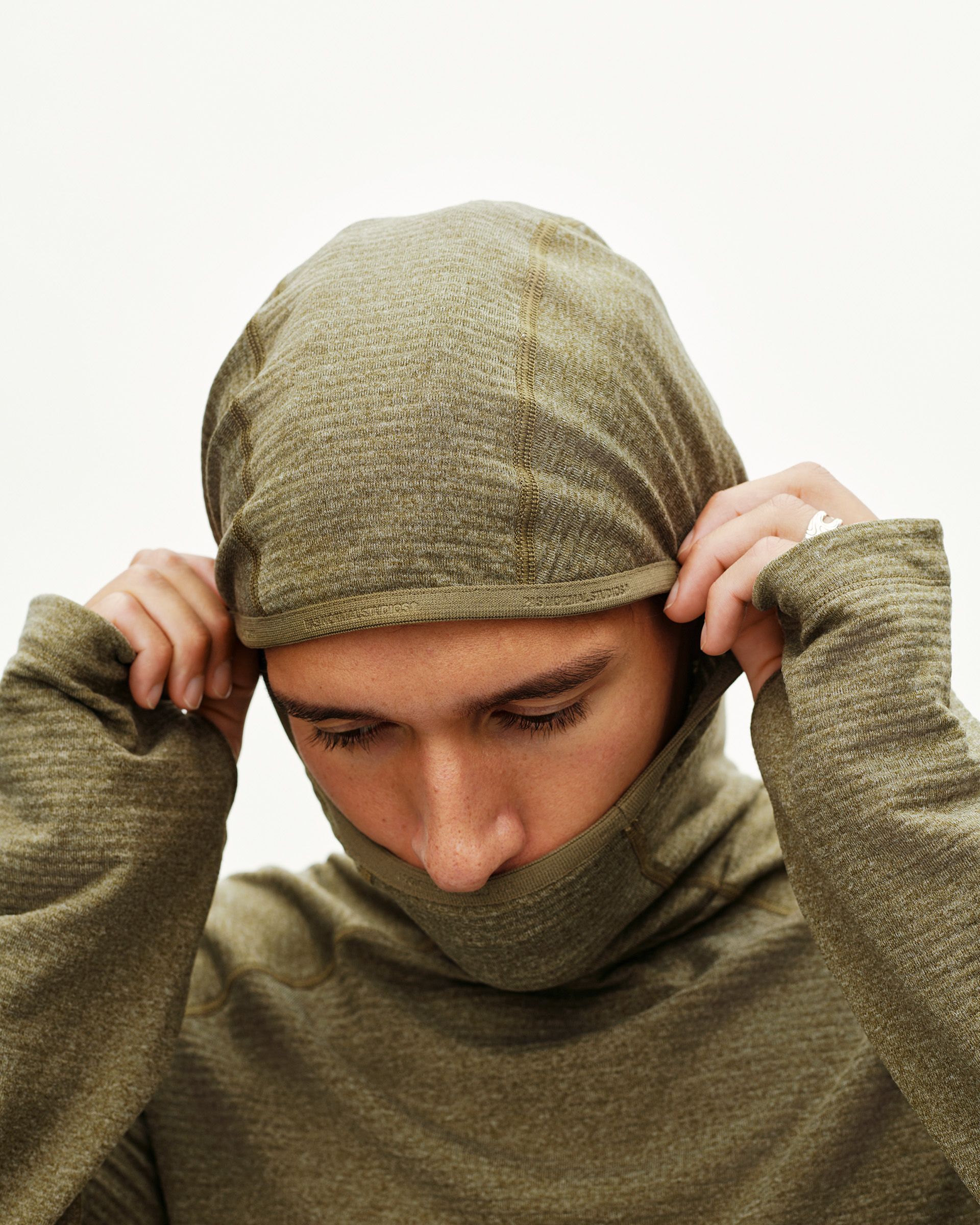 Moss Brown Balance Thermal cycling hoodie on model, front view with balaclava-style hood pulled up