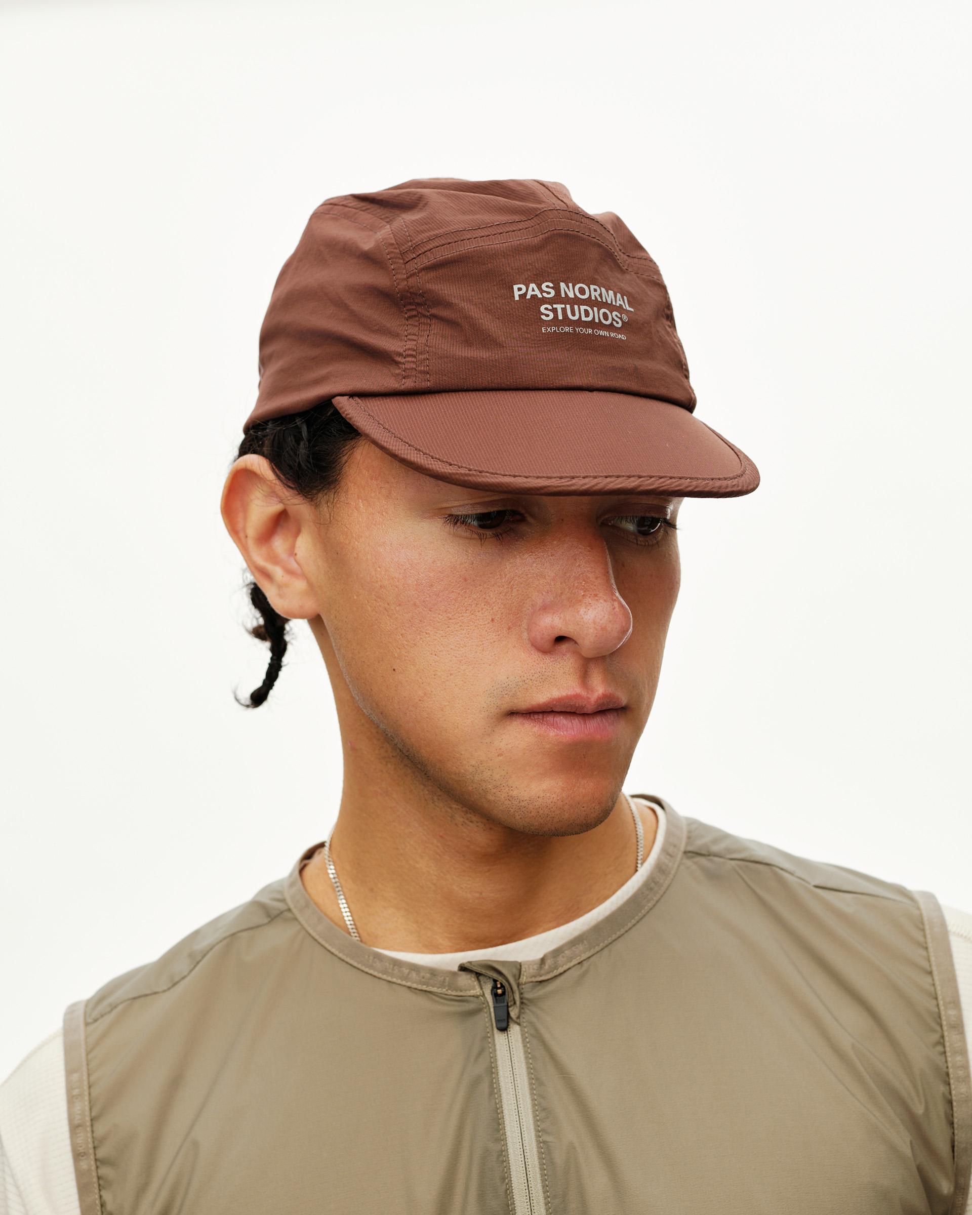 Maroon Brown Balance cap on model, front three-quarter view with white logo print on crown