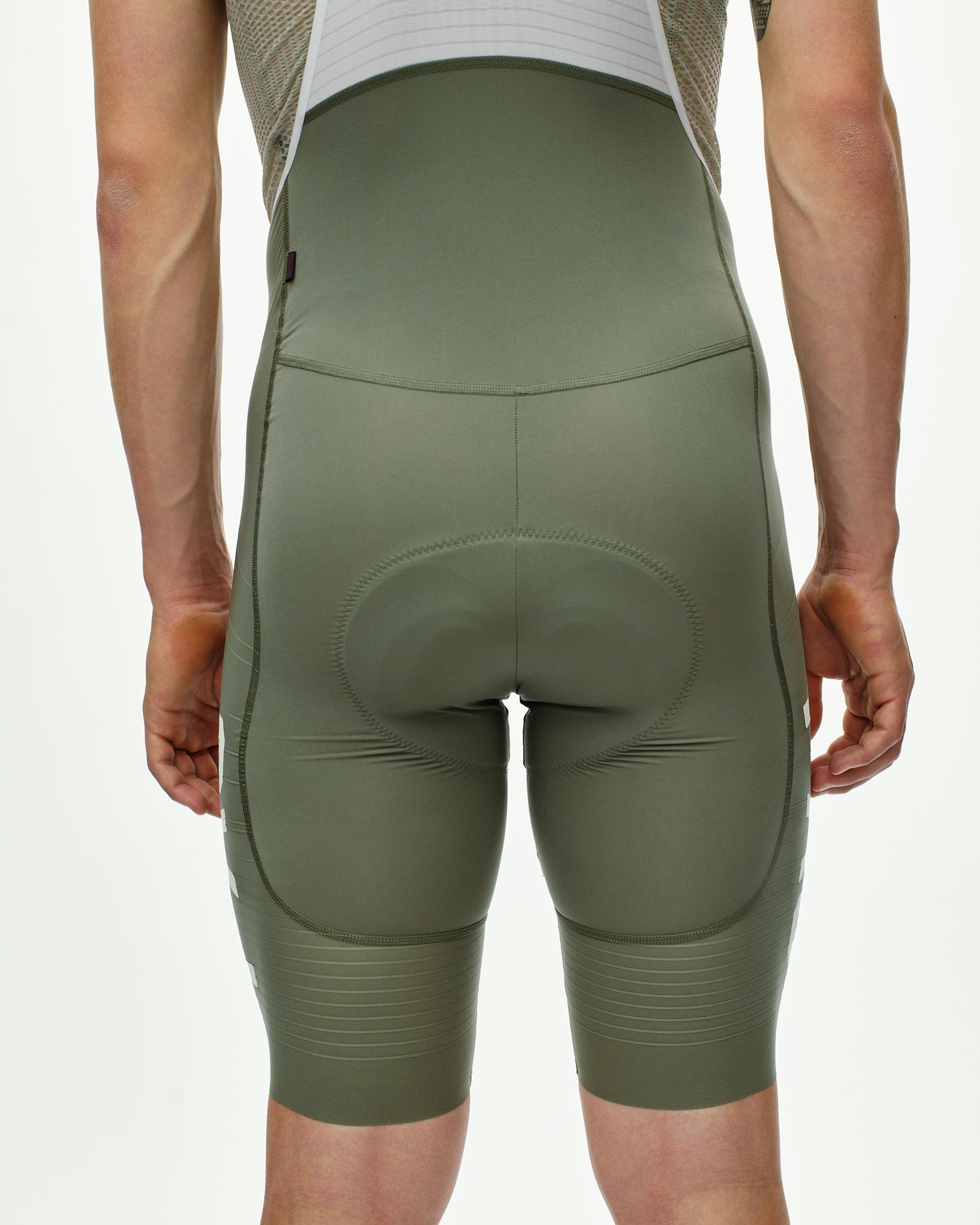 Grey PAS Mechanism Pro cycling bibs, rear view on model with ribbed leg bands