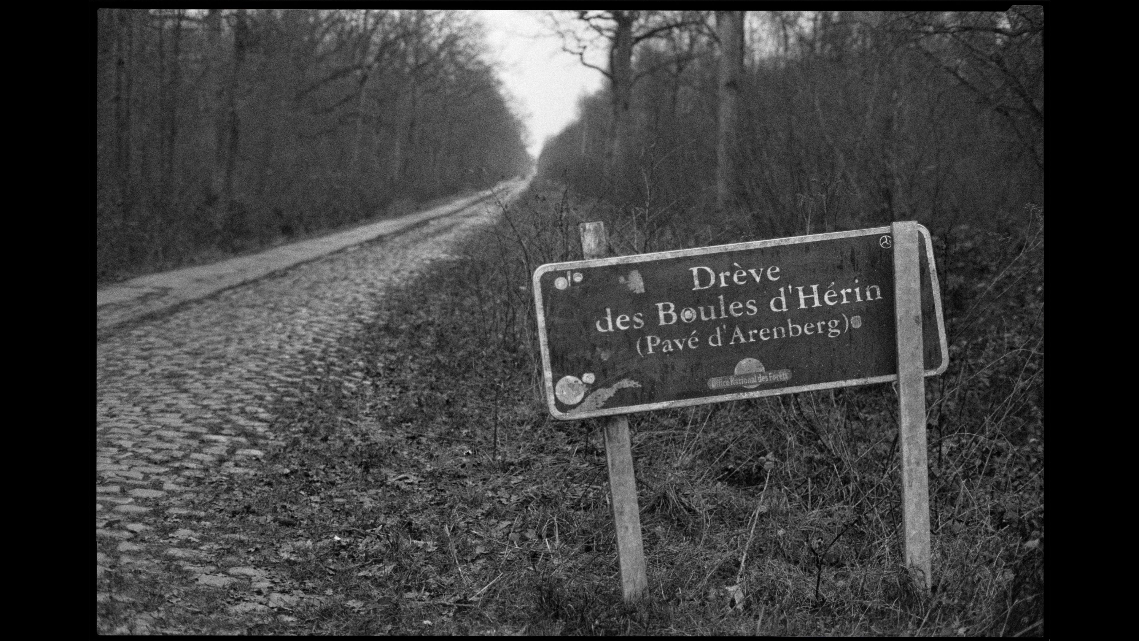 Black and white photo of Belgian road sign for Drève des Boules d'Hérin cobbled cycling route