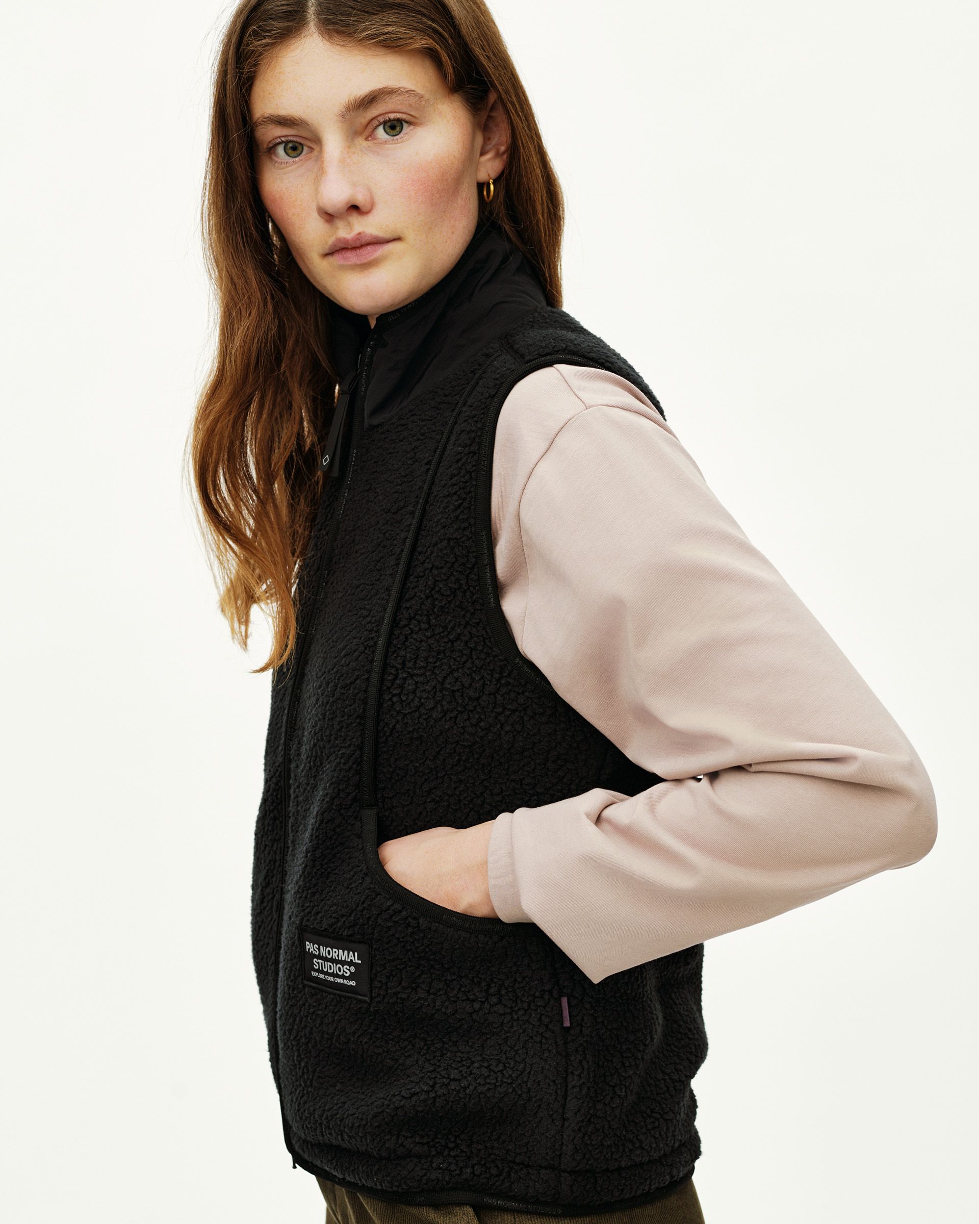 Black Off-Race Pile Fleece Vest on model, three-quarter view with branded label patch and hand pocket