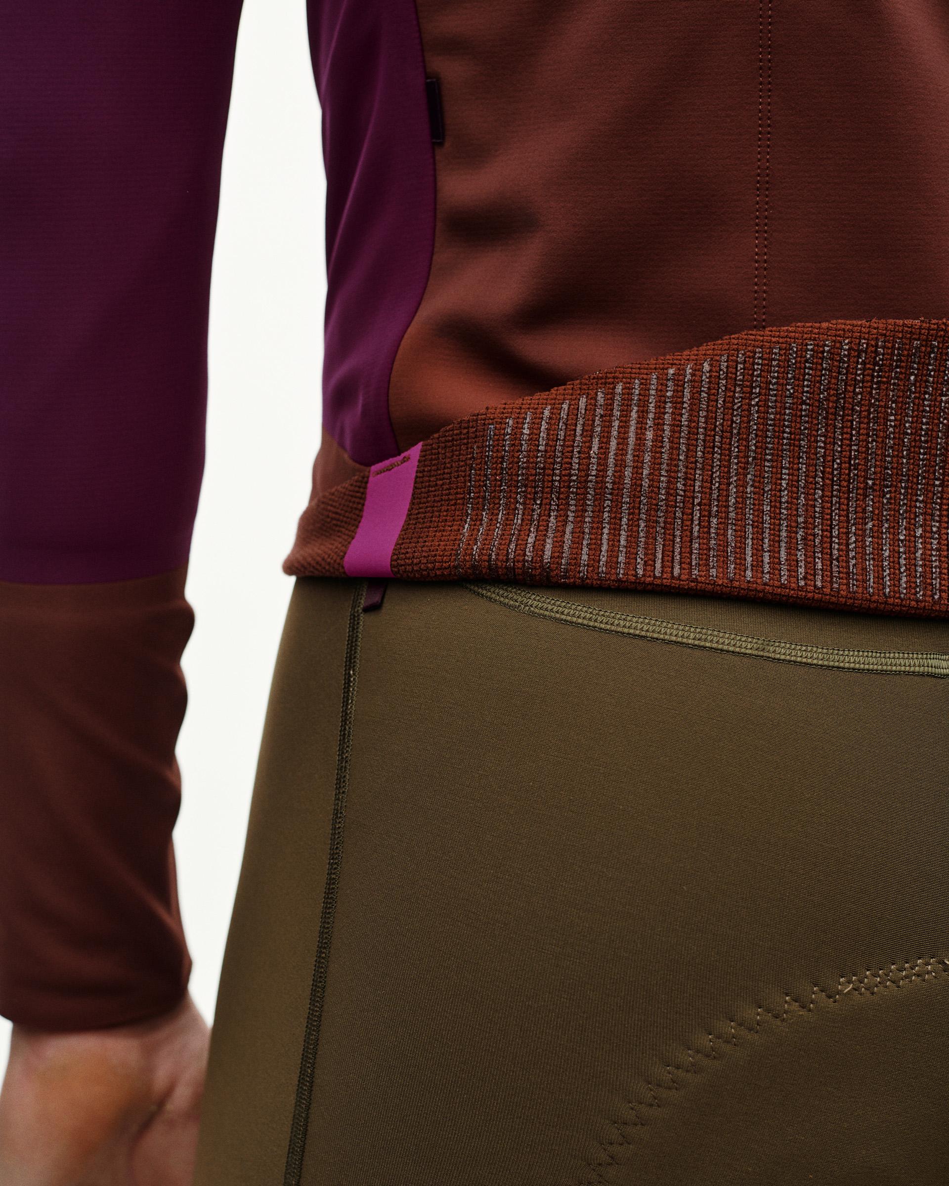 Dark Purple PAS Mechanism Thermal cycling jacket, side detail on model showing ribbed hem and color-block panels