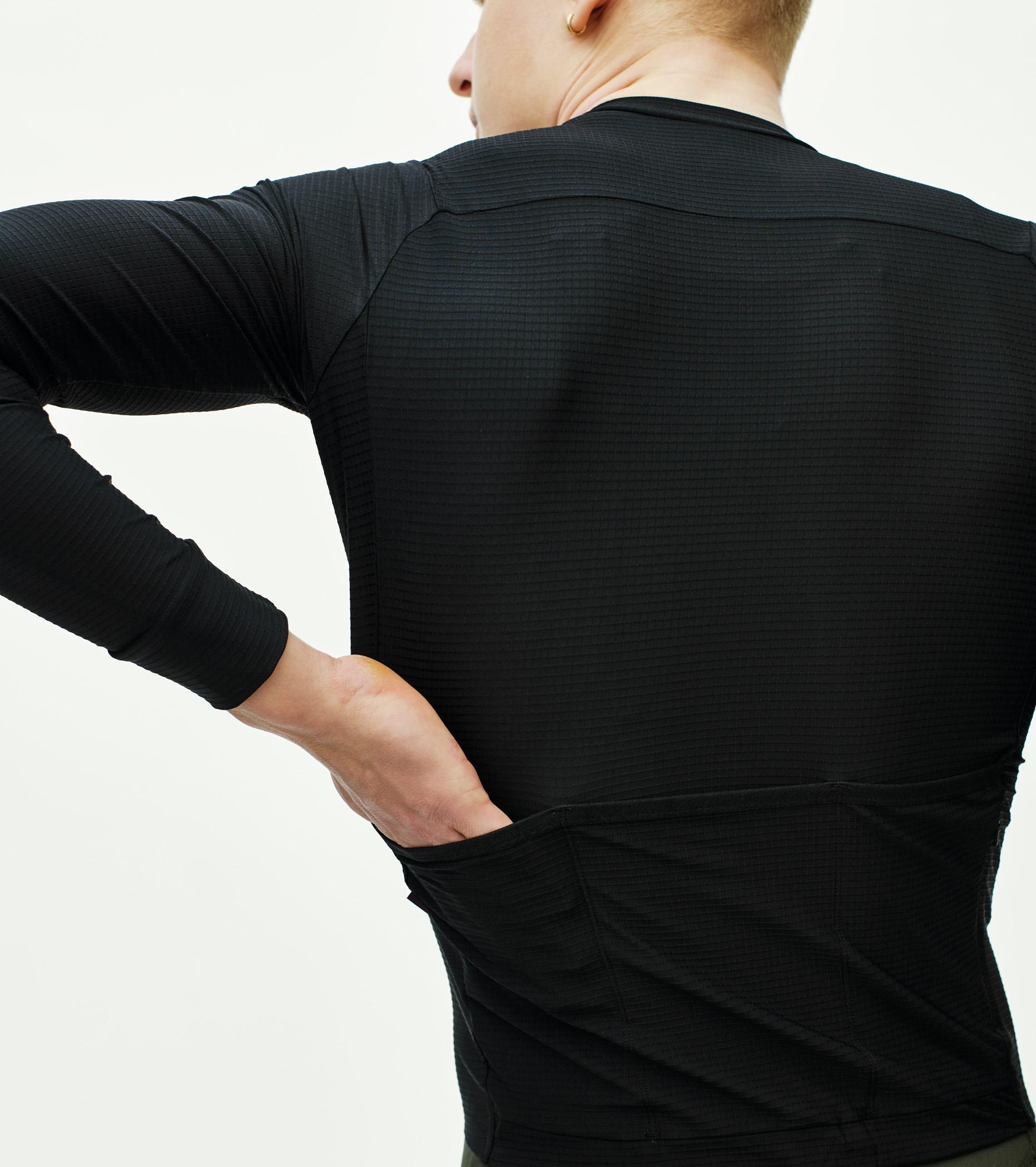 Black Mechanism Pro long sleeve cycling jersey on model, rear view with textured fabric and rear pockets