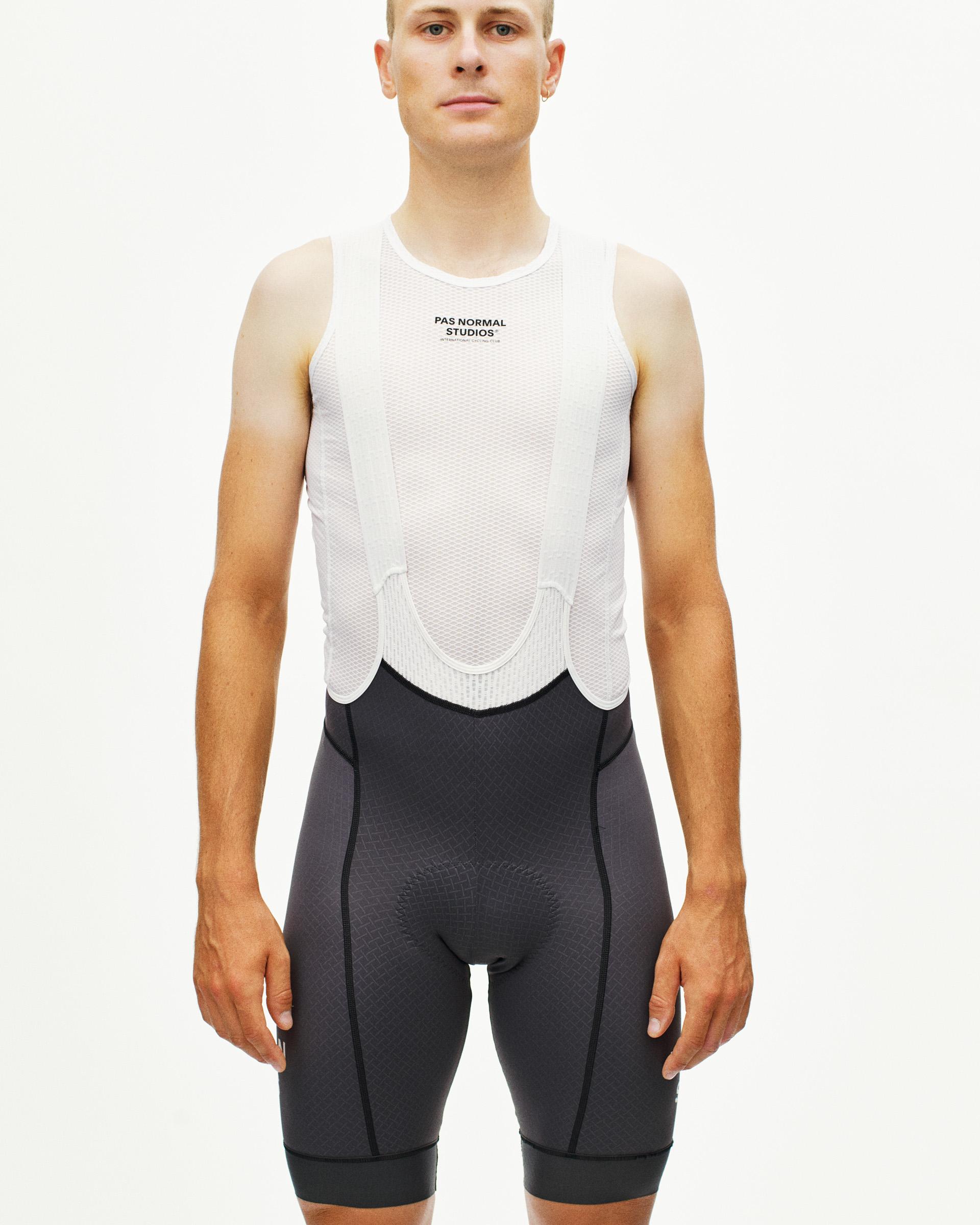 Grey Mechanism cycling bibs on model with white mesh base layer and black chest logo