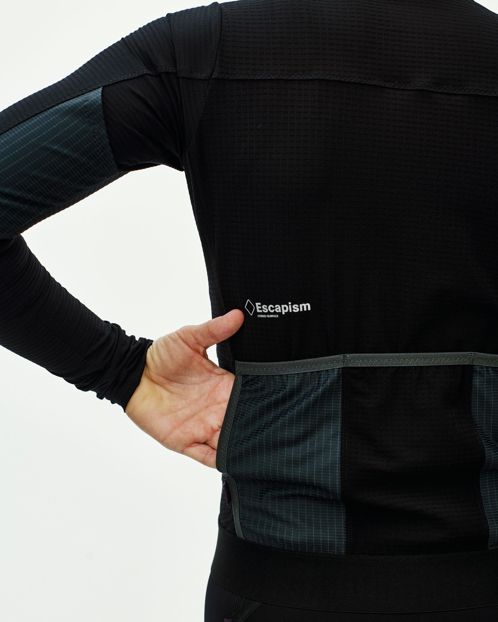 Black Escapism long sleeve cycling jersey on model with dark green contrast panels and pockets