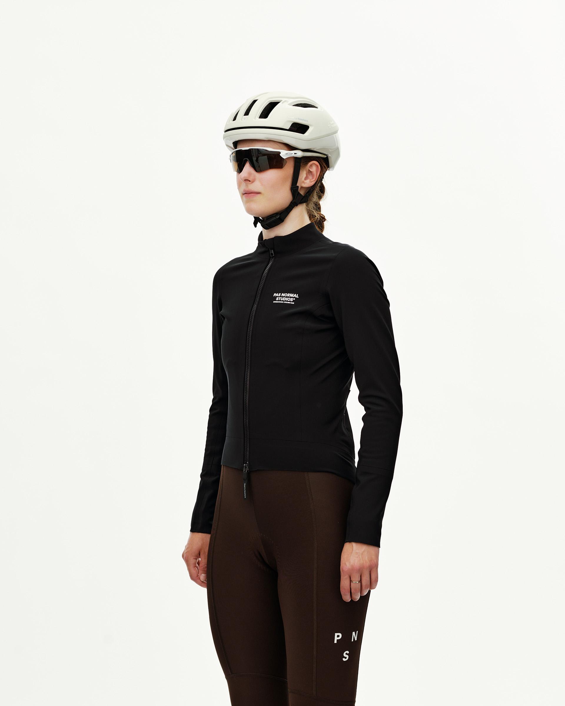 Black Mechanism Thermal women's cycling jacket on model, three-quarter front view with full zip and white chest logo