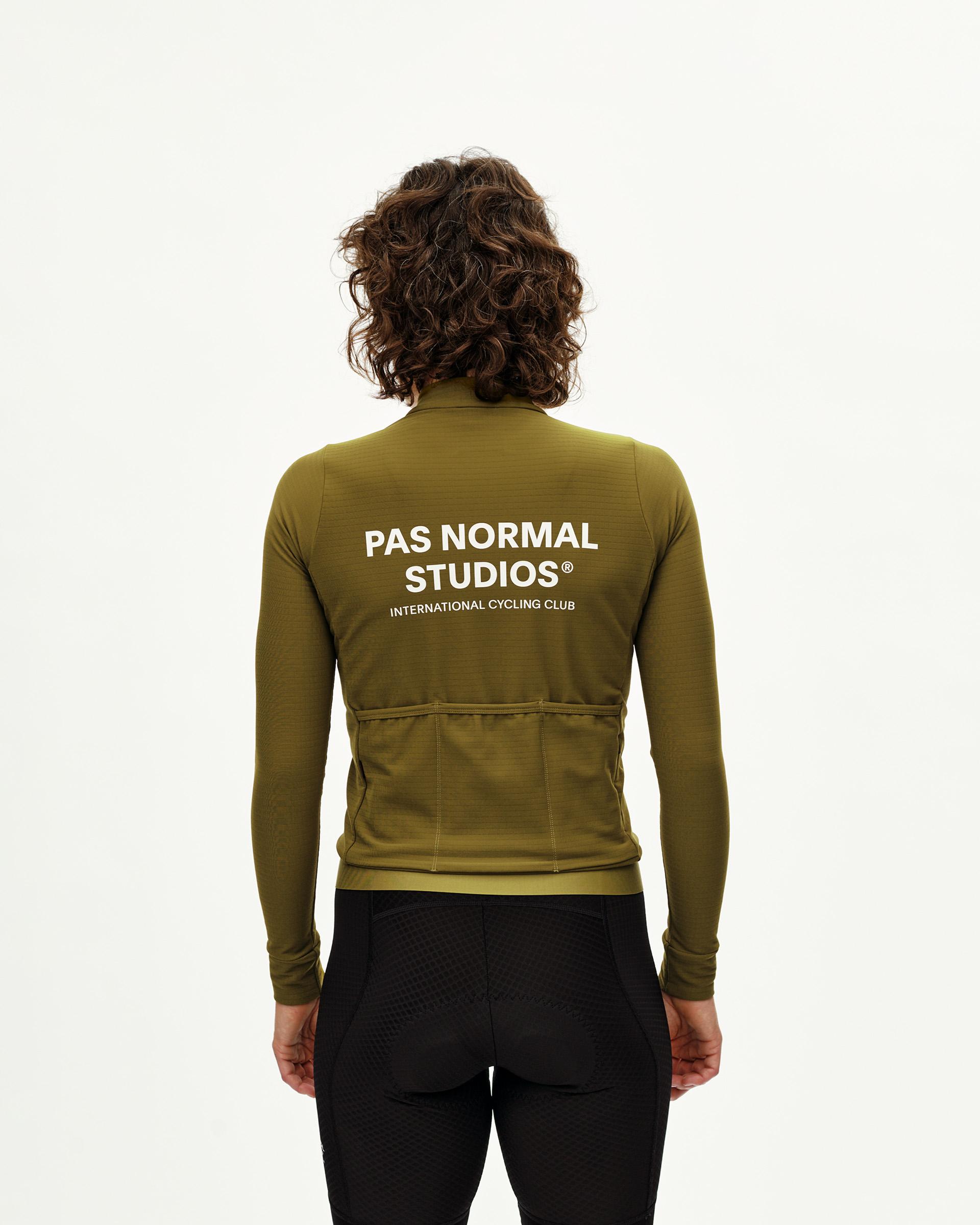 Khaki Green Essential long sleeve cycling jersey on model, rear view with white back print and rear pockets