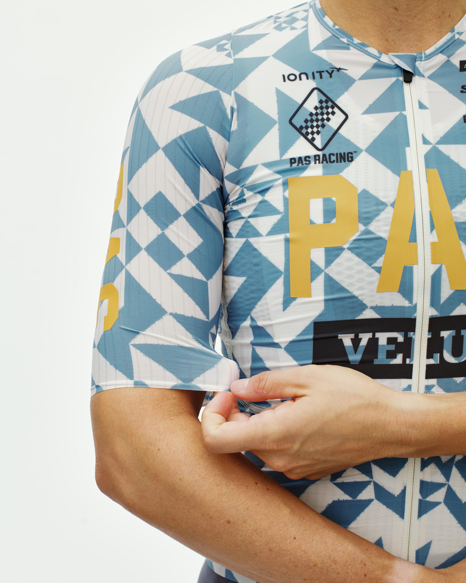 Origami Light Blue Mechanism Pro women's cycling jersey, front detail on model with geometric print and gold chest lettering