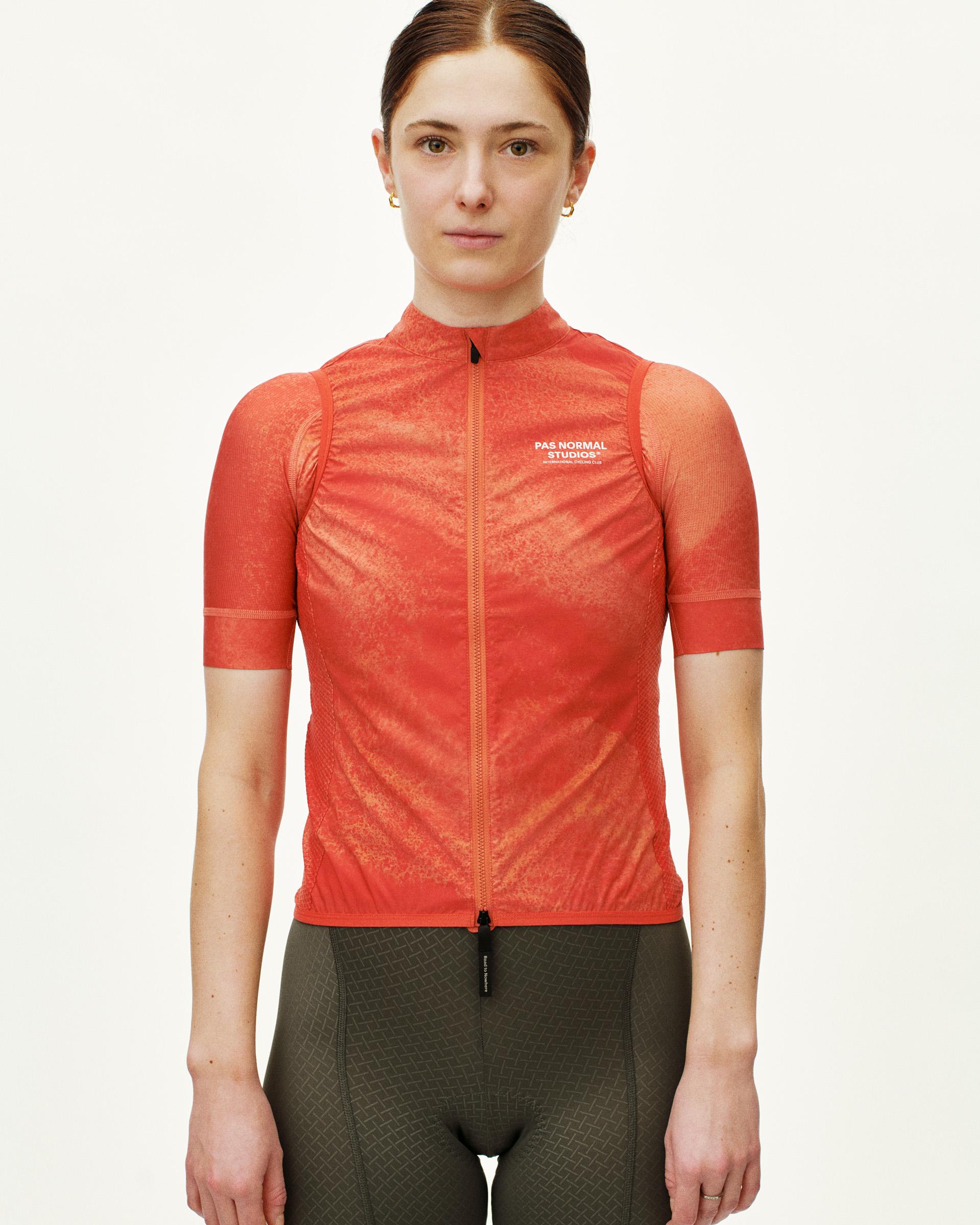 Orange Mechanism Stow Away cycling gilet on model with textured front panel and full zip