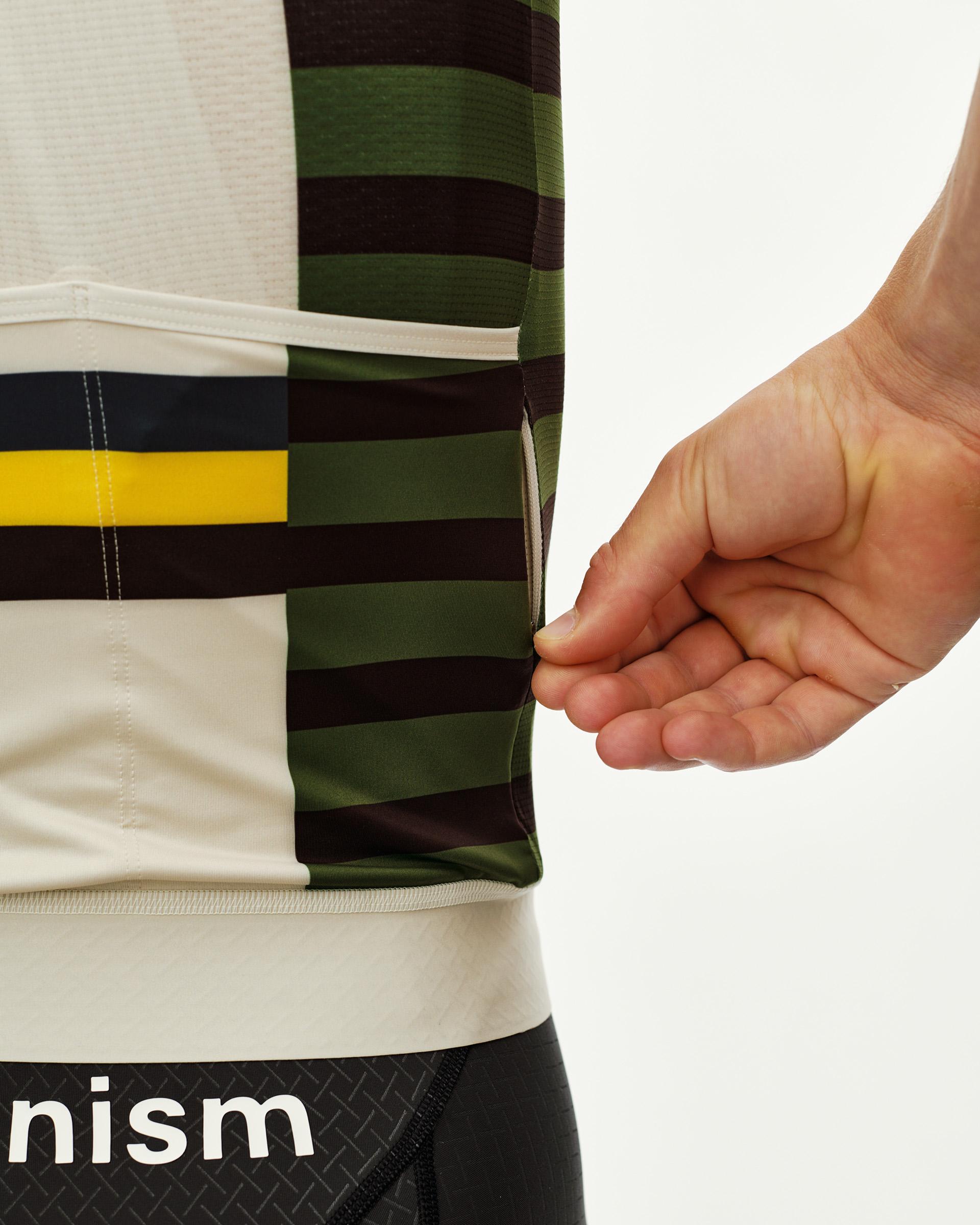 International Sand Mechanism cycling jersey, side detail on model with multicolor stripe panel and rear pocket opening