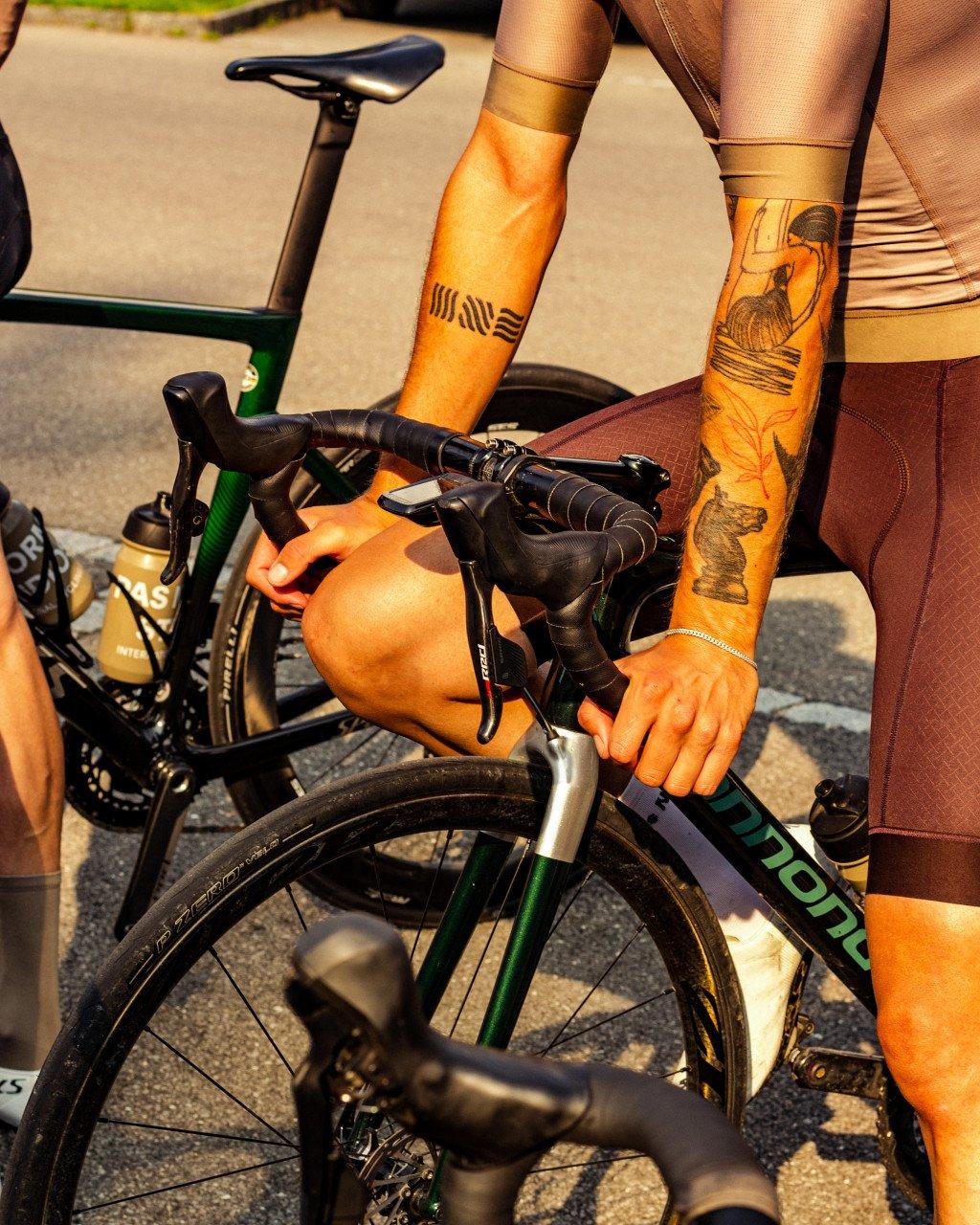Model wearing orange cycling kit with graphic print on time trial bike