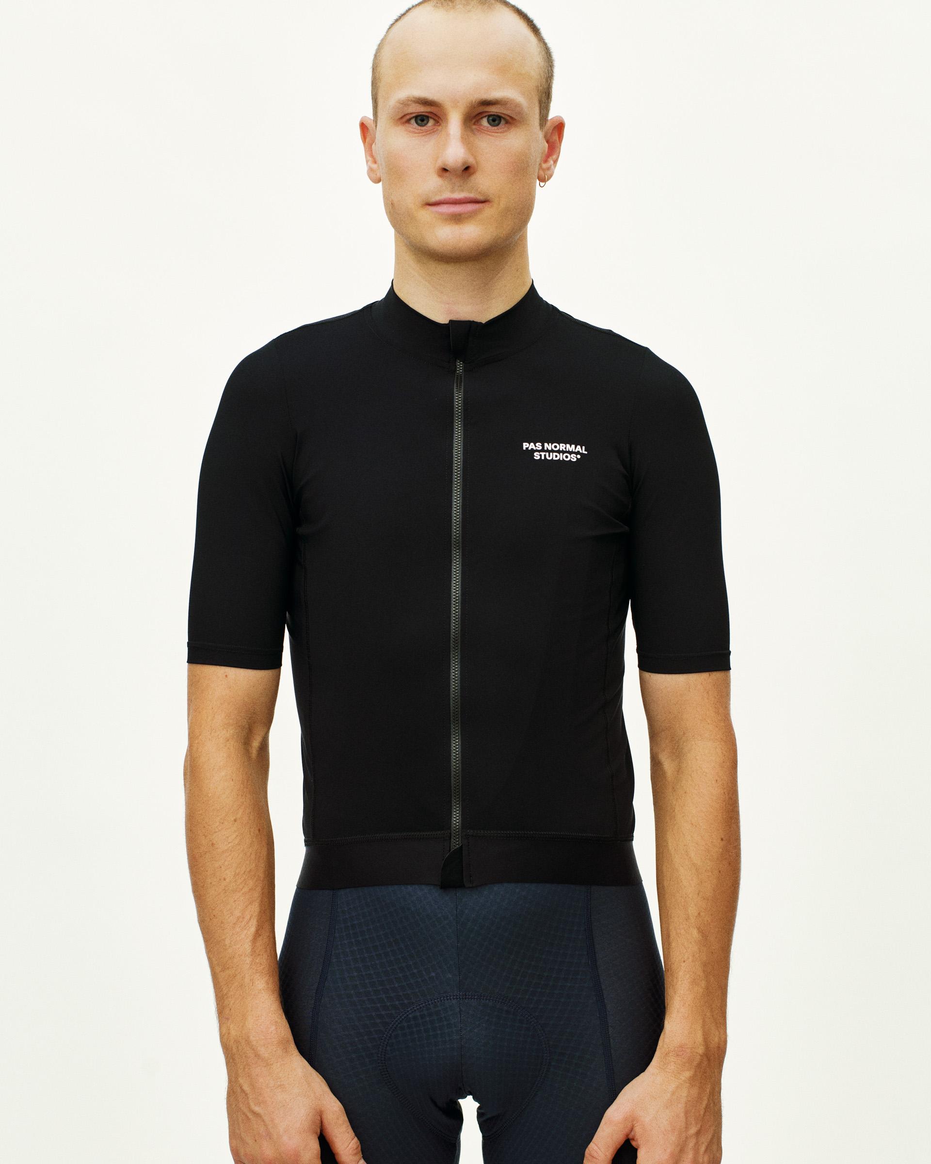 Black Essential cycling jersey on model, front view with full zip and white chest logo