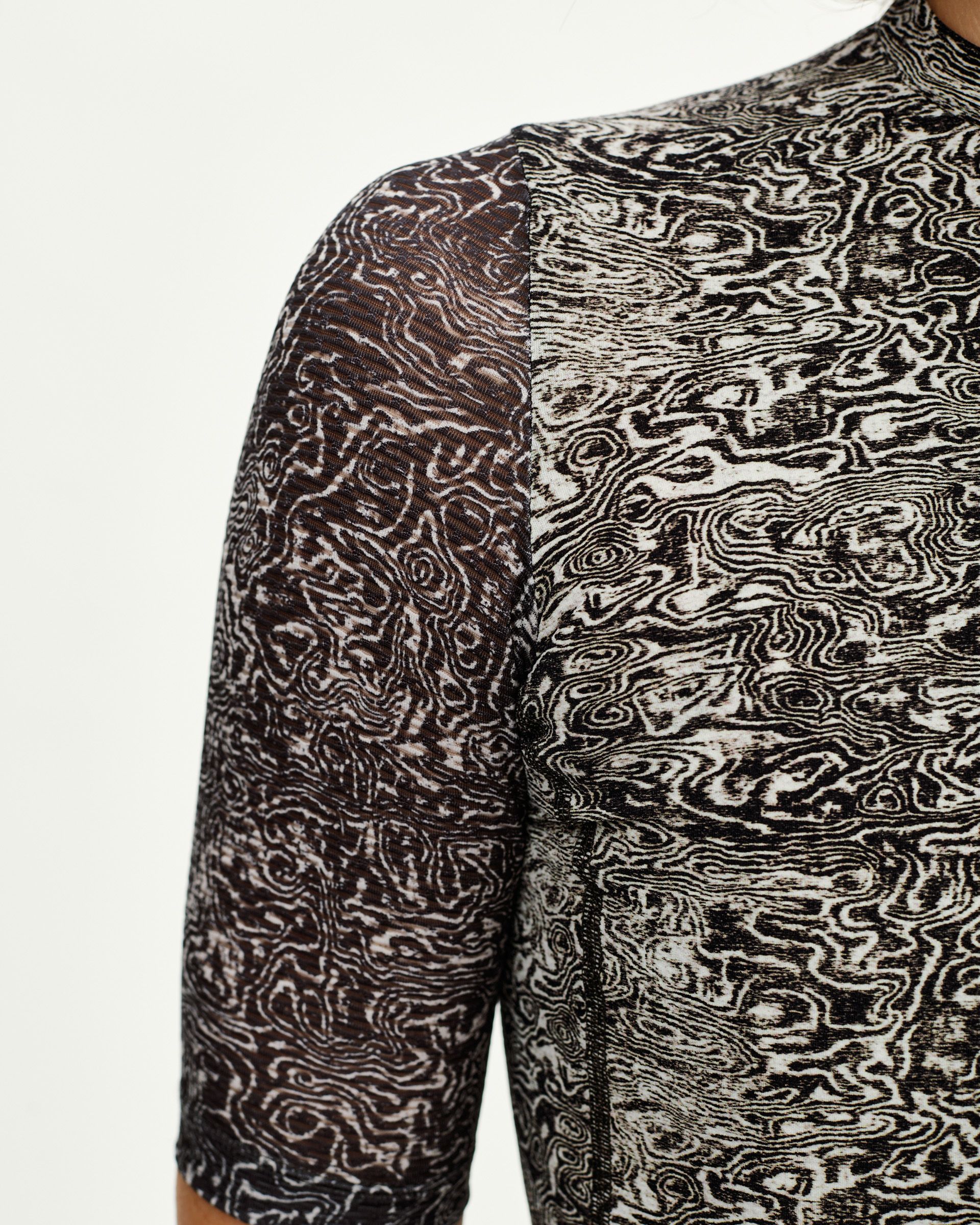 Off White Essential women's cycling jersey, front detail on model with all-over swirling grain print