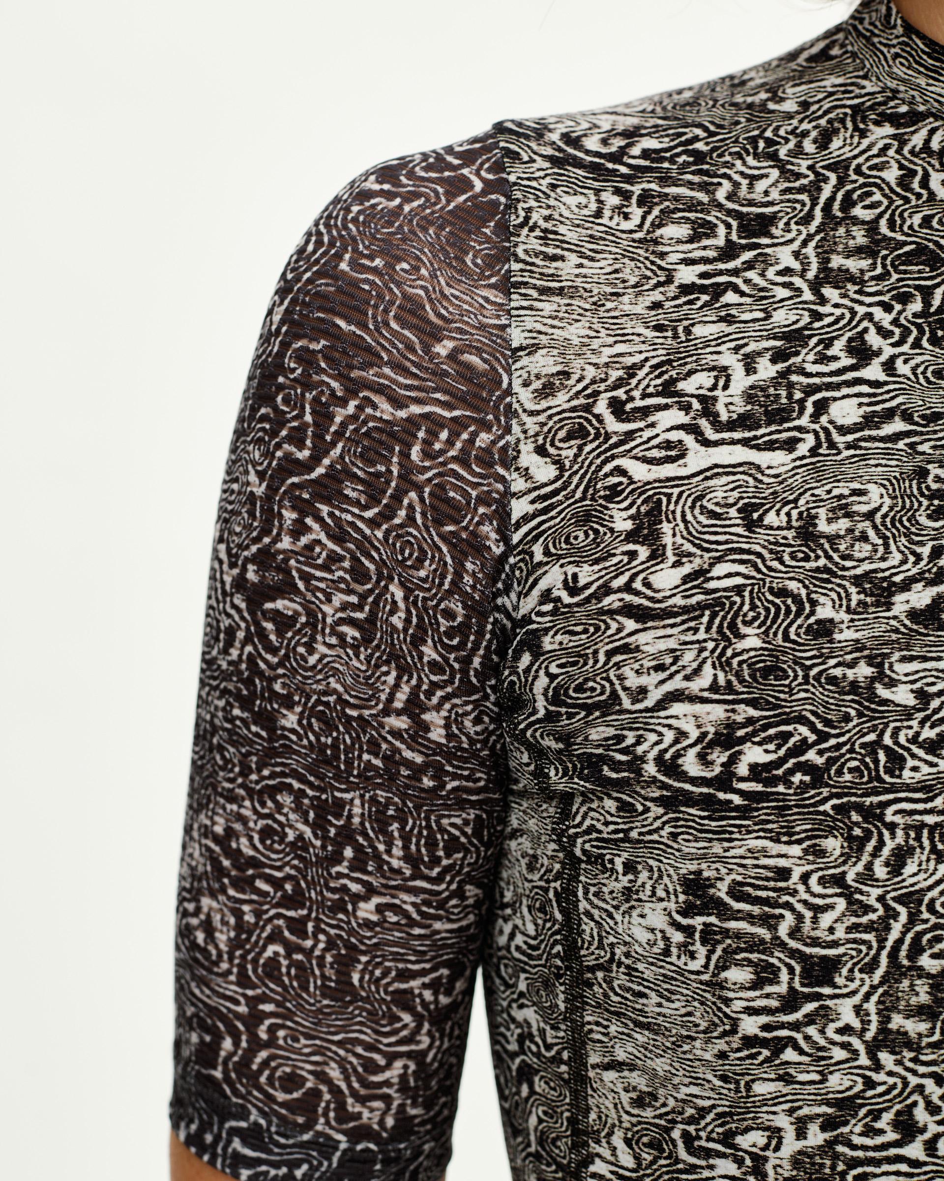 Off White Essential women's cycling jersey, front detail on model with all-over swirling grain print