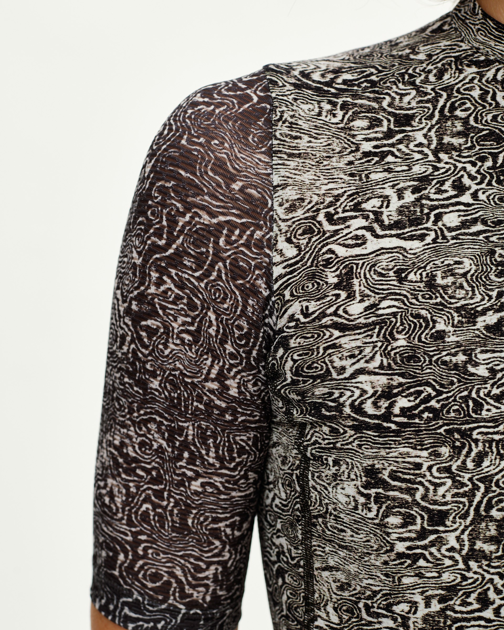 Off White Essential women's cycling jersey, front detail on model with all-over swirling grain print