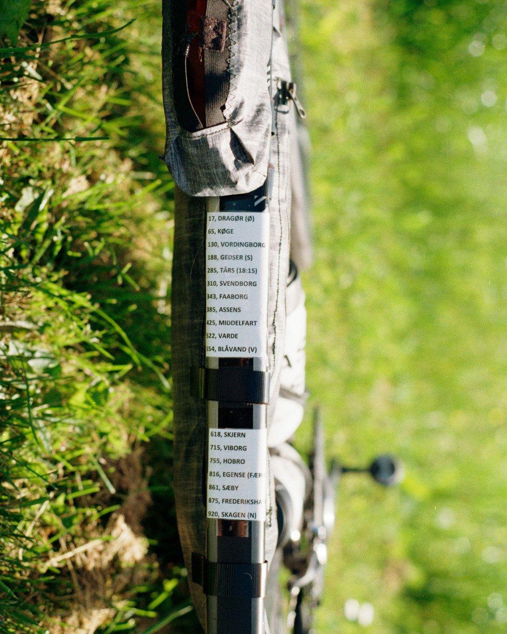 Cycling gear and distance markers attached to wooden post in forest setting