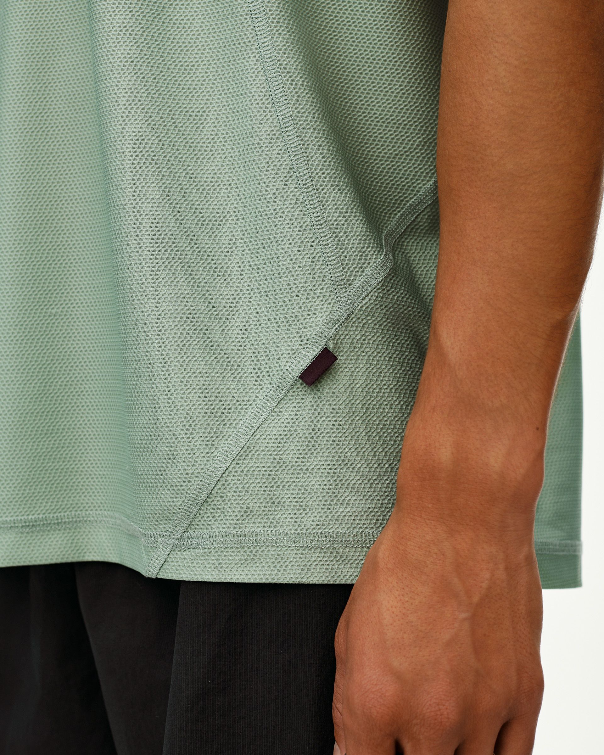 Green Sage Balance T-Shirt, side detail on model with textured mesh fabric and small woven tab