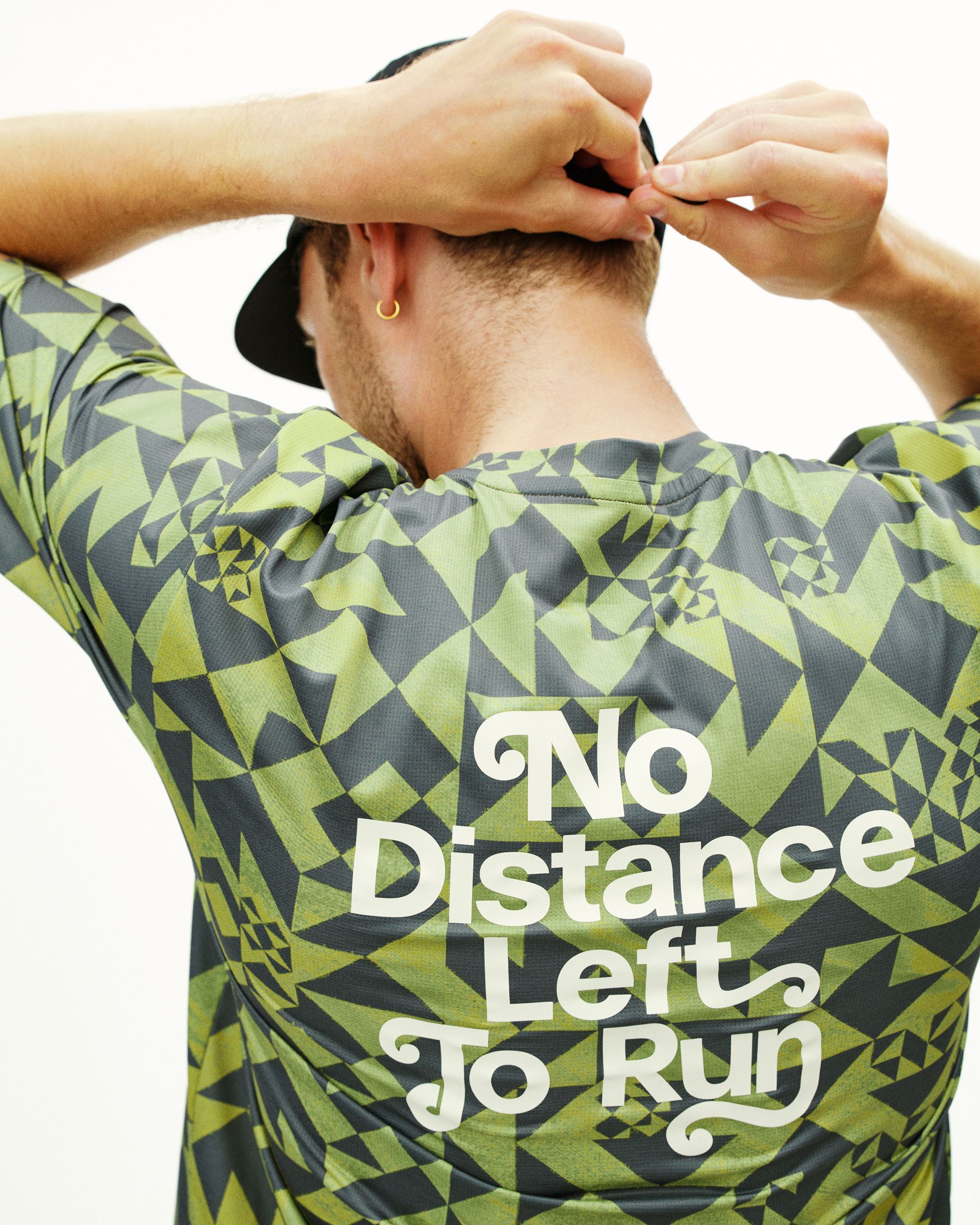 Green Balance t-shirt on model, rear view with geometric origami print and white text