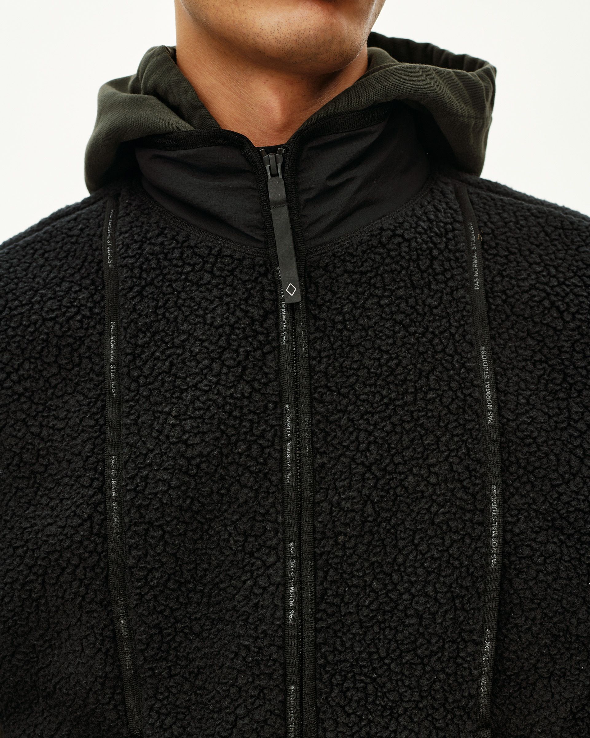 Black Off-Race Pile Fleece Vest, front detail on model with logo zip tape and contrast hood lining
