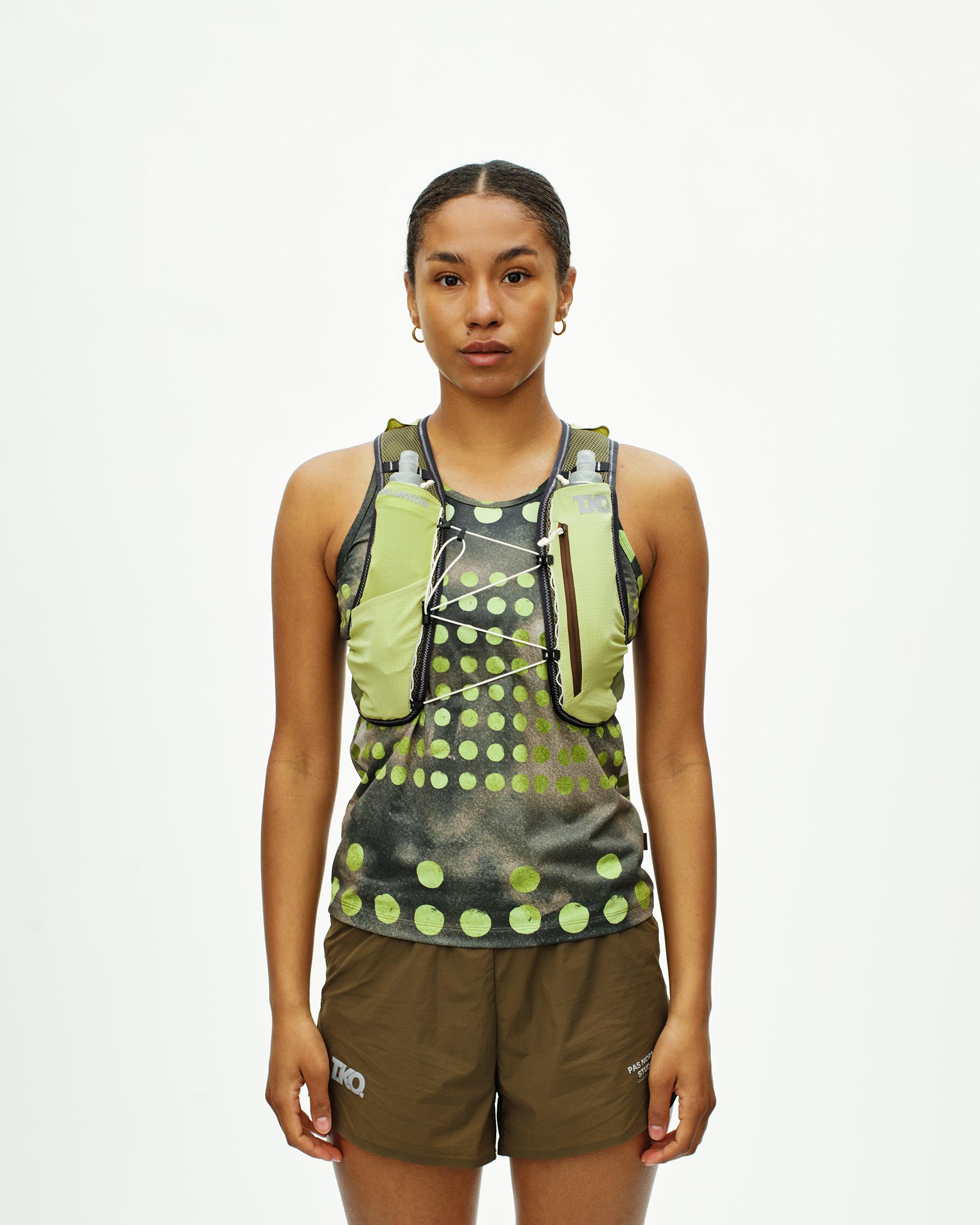 Green Salomon Race Skin 2 running vest on model with water bottles and printed design