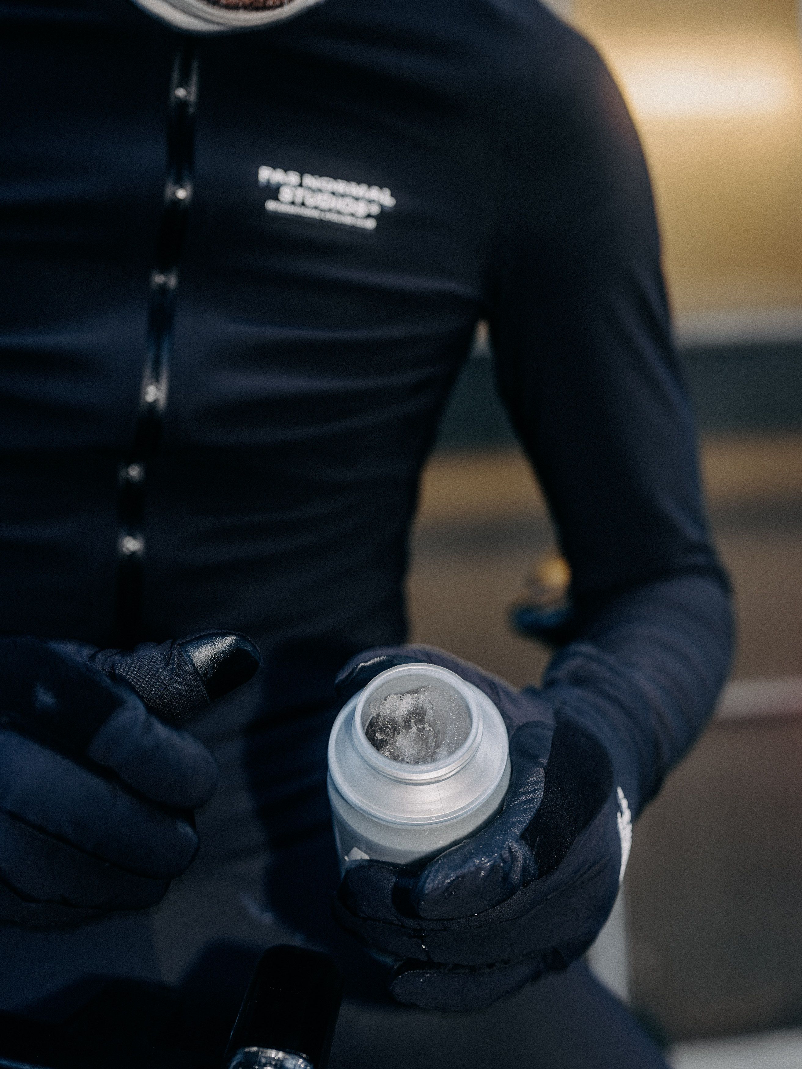 Model wearing navy long sleeve jersey with chest branding holding water bottle