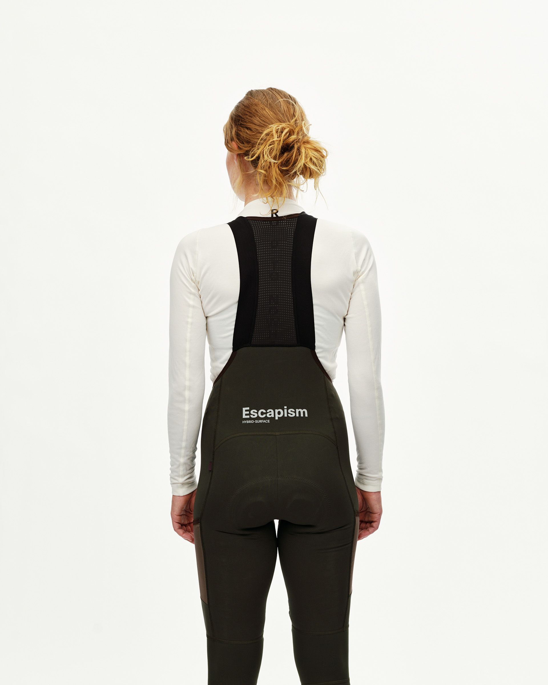 Dark Olive Escapism Long Cargo cycling bibs on model, rear view with mesh bib straps and white back print