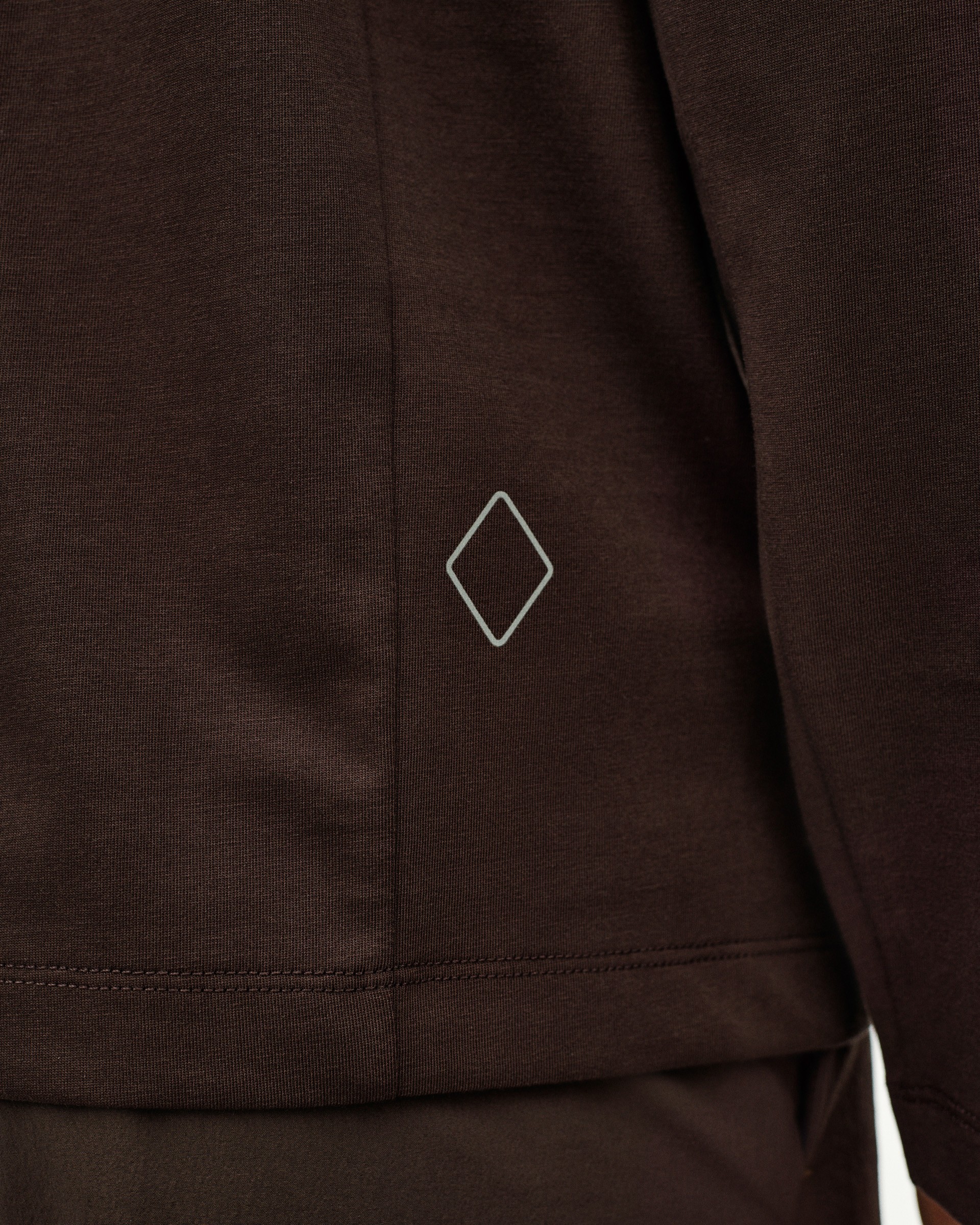 Dark Purple Off-Race Cotton Tech long sleeve t-shirt detail view with white diamond logo on hem
