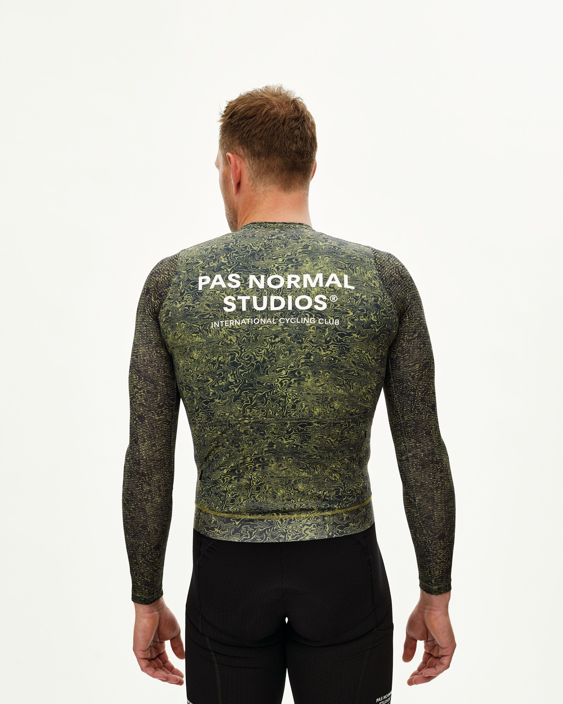 Dark Lime Essential long sleeve cycling jersey on model, rear view with allover grain print and white back logo