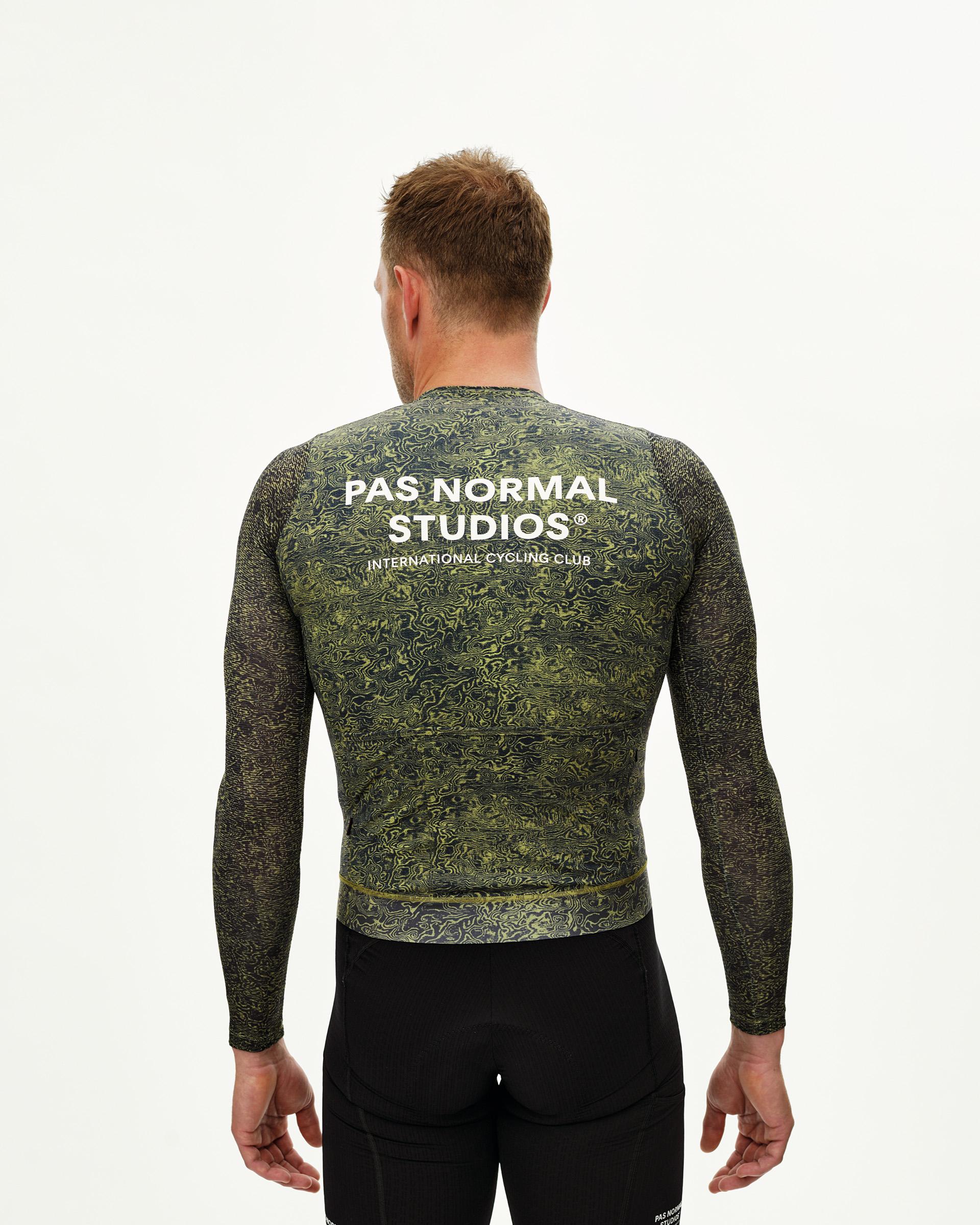 Dark Lime Essential long sleeve cycling jersey on model, rear view with allover grain print and white back logo