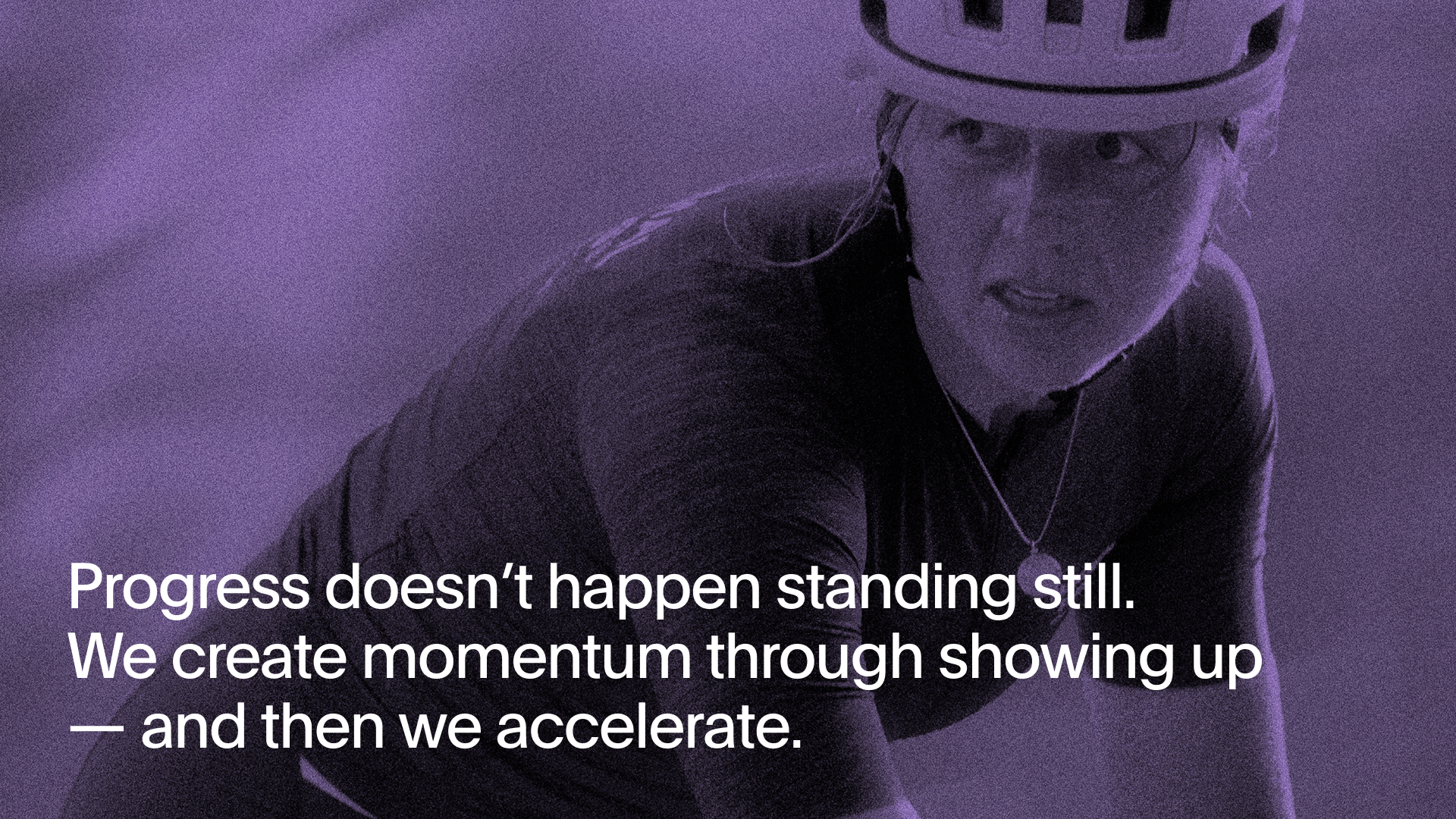 Model wearing cycling jersey and helmet in purple-tinted studio shot