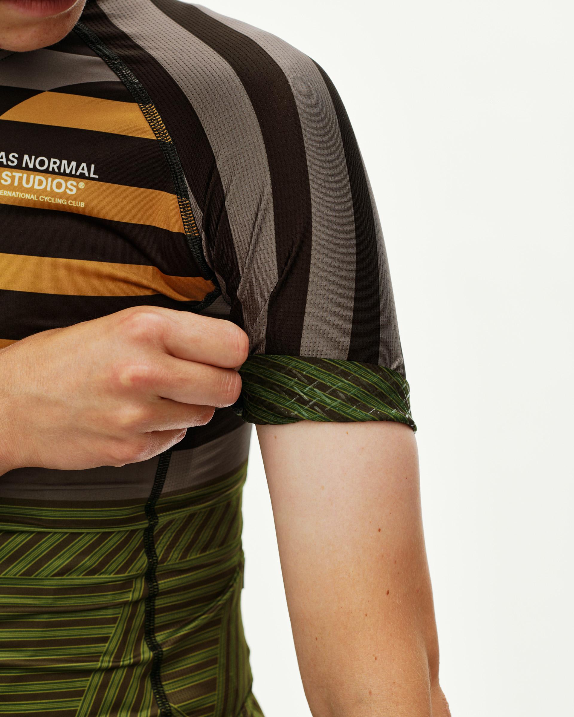 International Earth Mechanism women's cycling jersey, side detail showing striped multicolor panel and green sleeve cuff