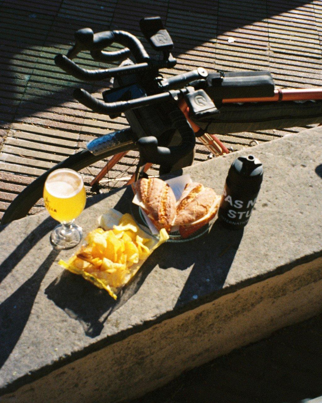 Cycling lifestyle scene with water bottle, snacks, and bicycle on wooden dock in sunlight