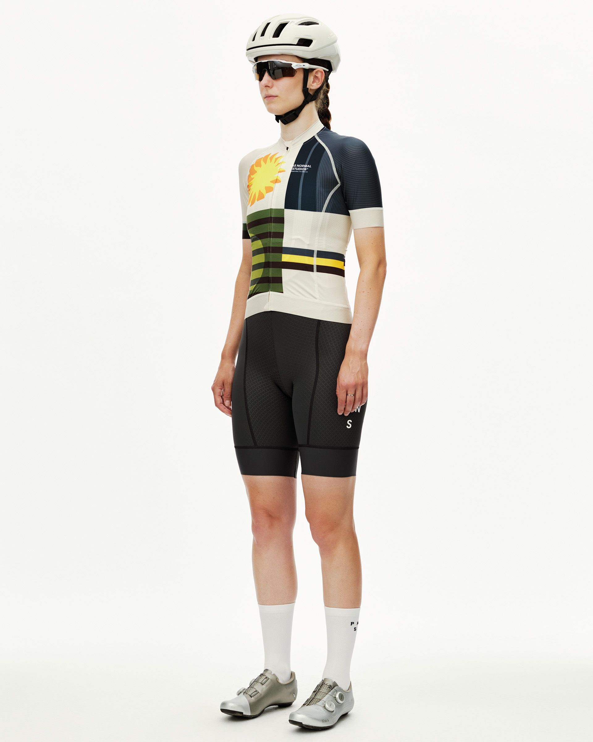International Sand Mechanism women's cycling jersey on model, three-quarter front view with multicolour sun and stripe print