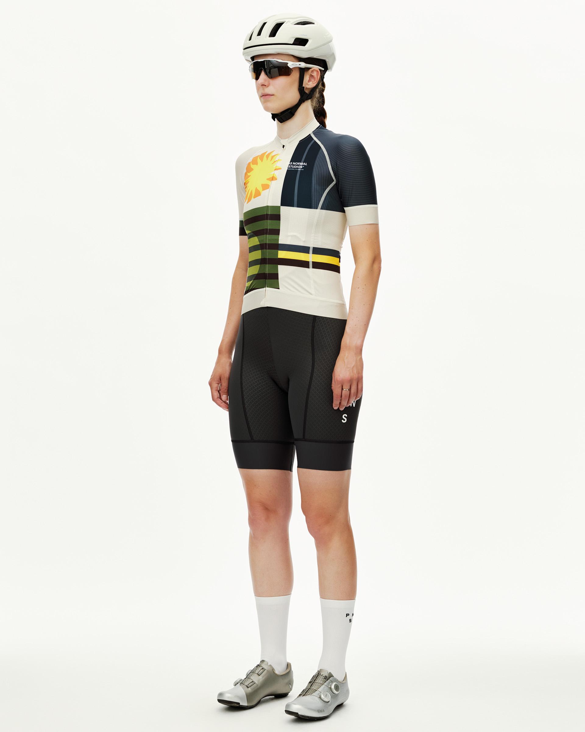 International Sand Mechanism women's cycling jersey on model, three-quarter front view with multicolour sun and stripe print